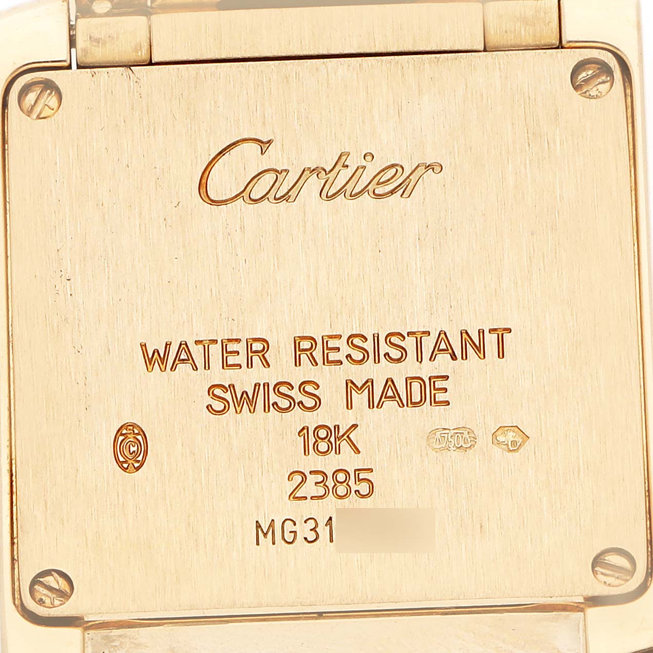 The image shows the back case of a Cartier Tank Française watch, highlighting engravings and details like "18K" and "Swiss Made."