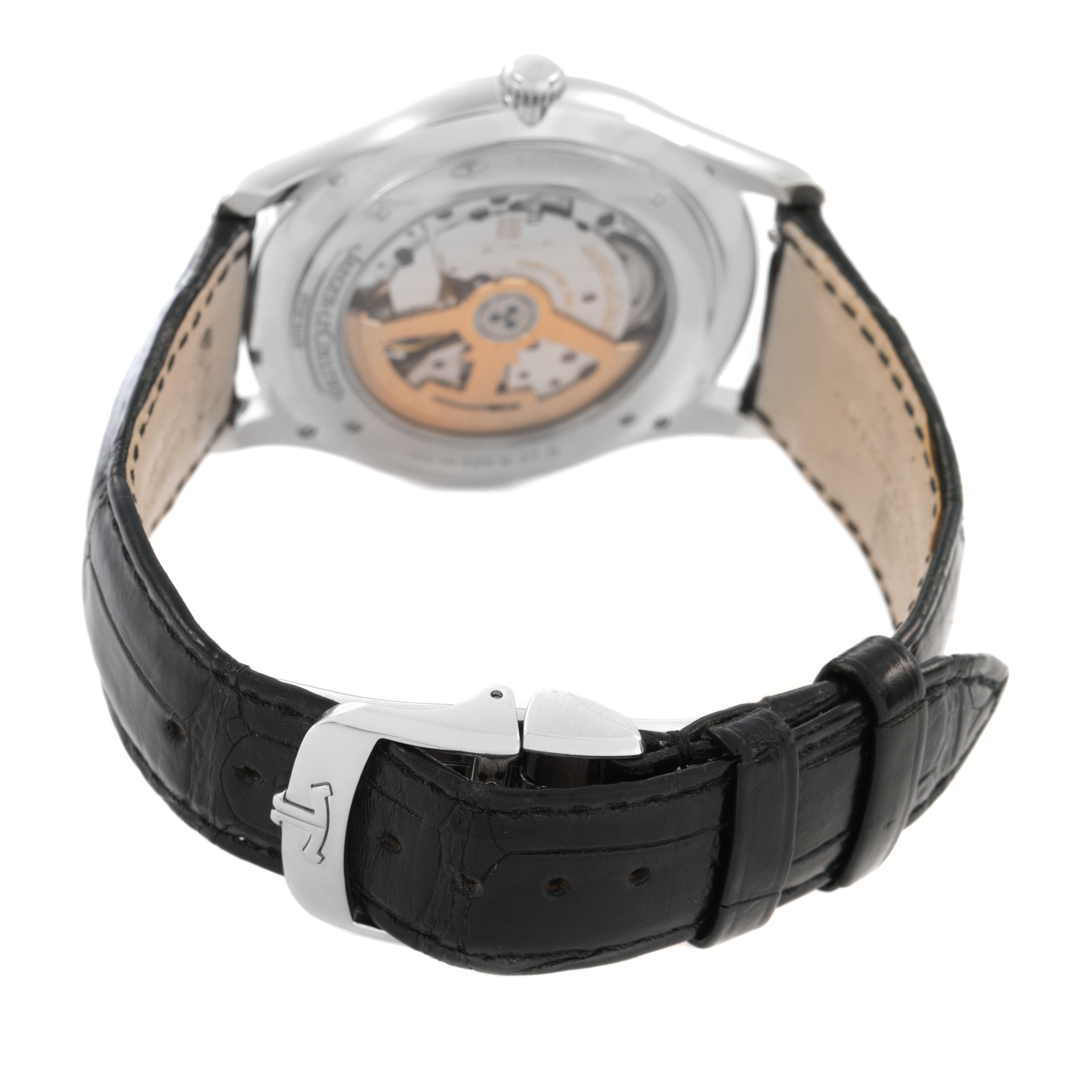 The Jaeger-LeCoultre Master watch is shown from the back, displaying its movement and leather strap with a deployment clasp.