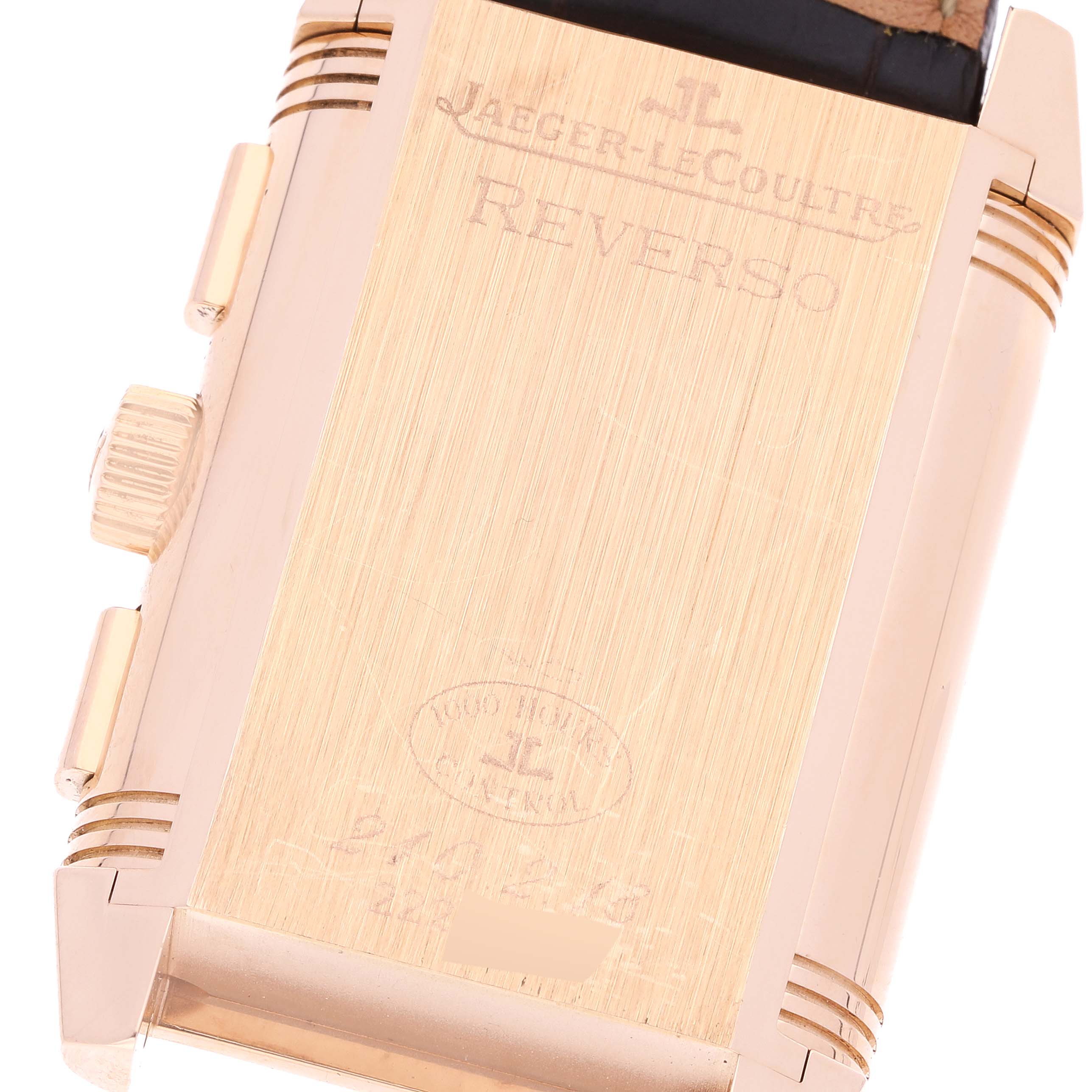 The image shows the back view of a Jaeger-LeCoultre Reverso watch case, focusing on its engravings and side crown.