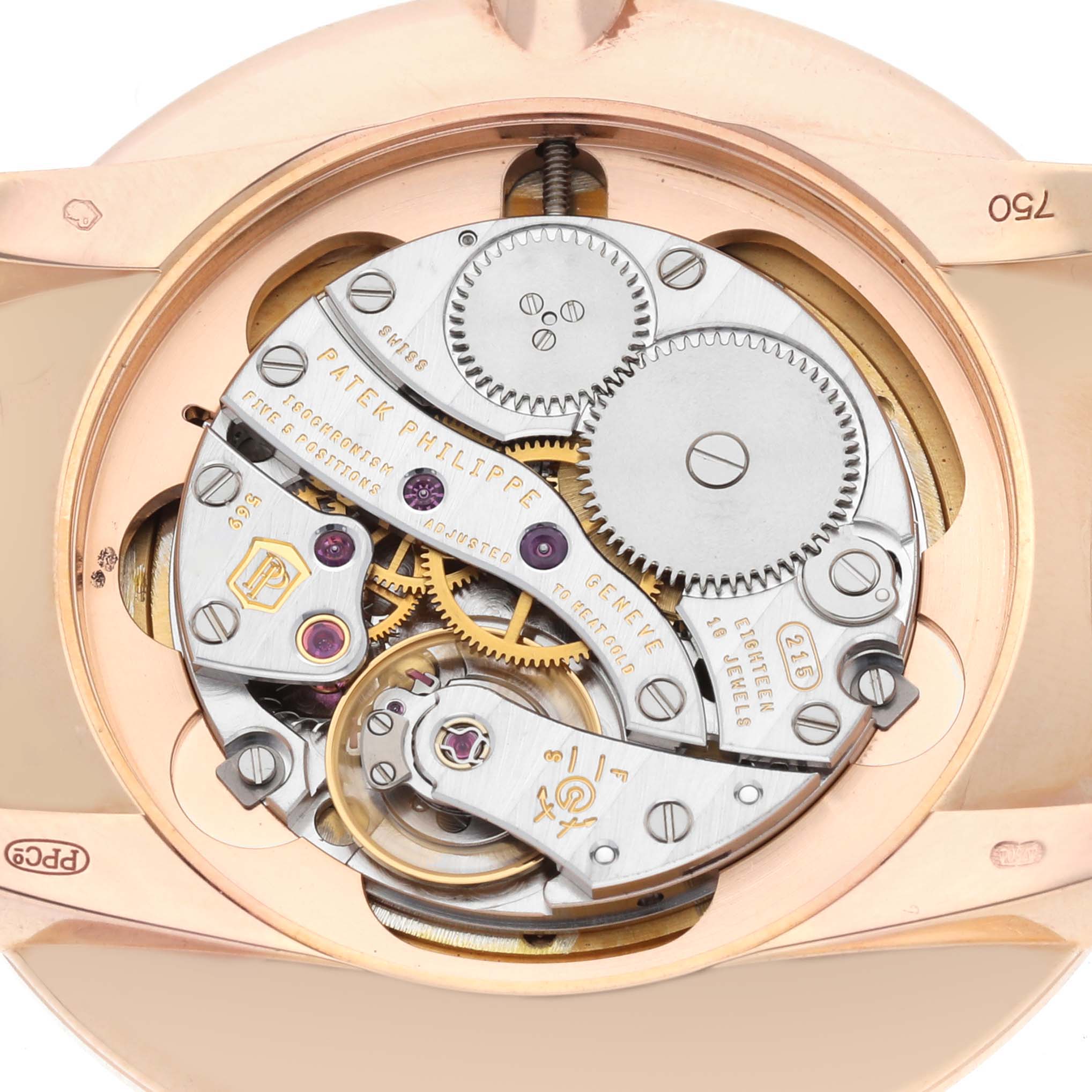 The image shows the movement of a Patek Philippe Calatrava 5123 Men
s Rose Gold Silver Dial watch from the back, revealing gears and mechanical components.