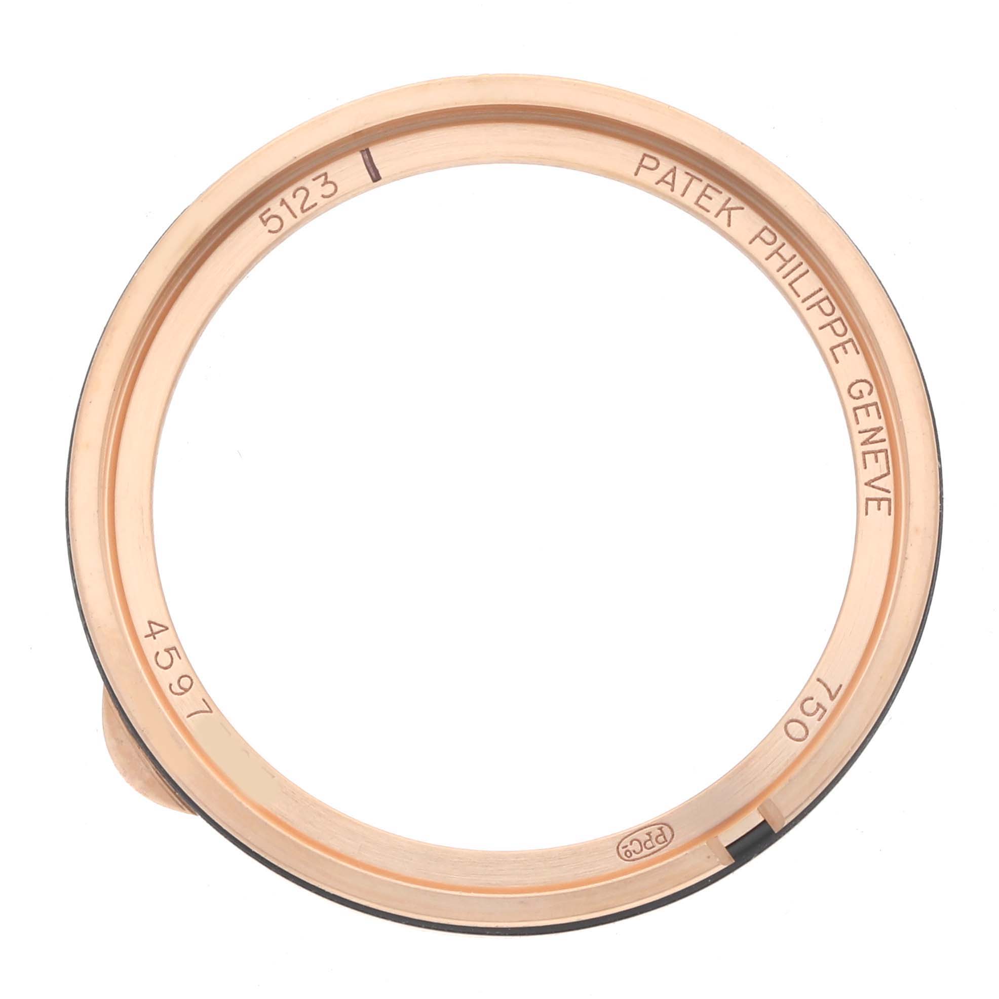 The image shows a Patek Philippe Calatrava 5123 Men
s Rose Gold Silver Dial watch bezel with engraved details, viewed from above.