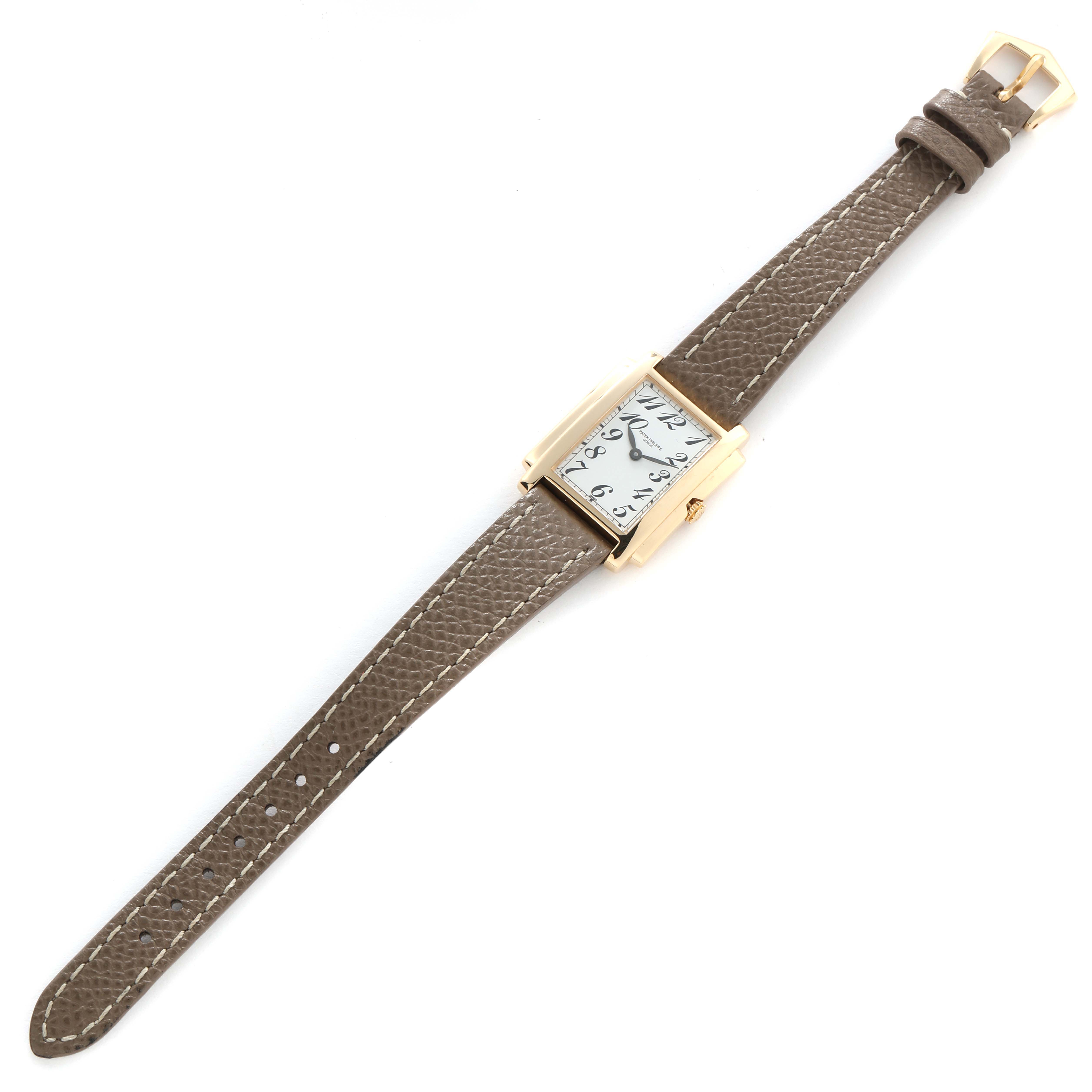 The Patek Philippe Gondolo 4824J Women
s Yellow Gold White Dial watch is shown at a slightly angled top-down view, highlighting its rectangular face and leather strap.