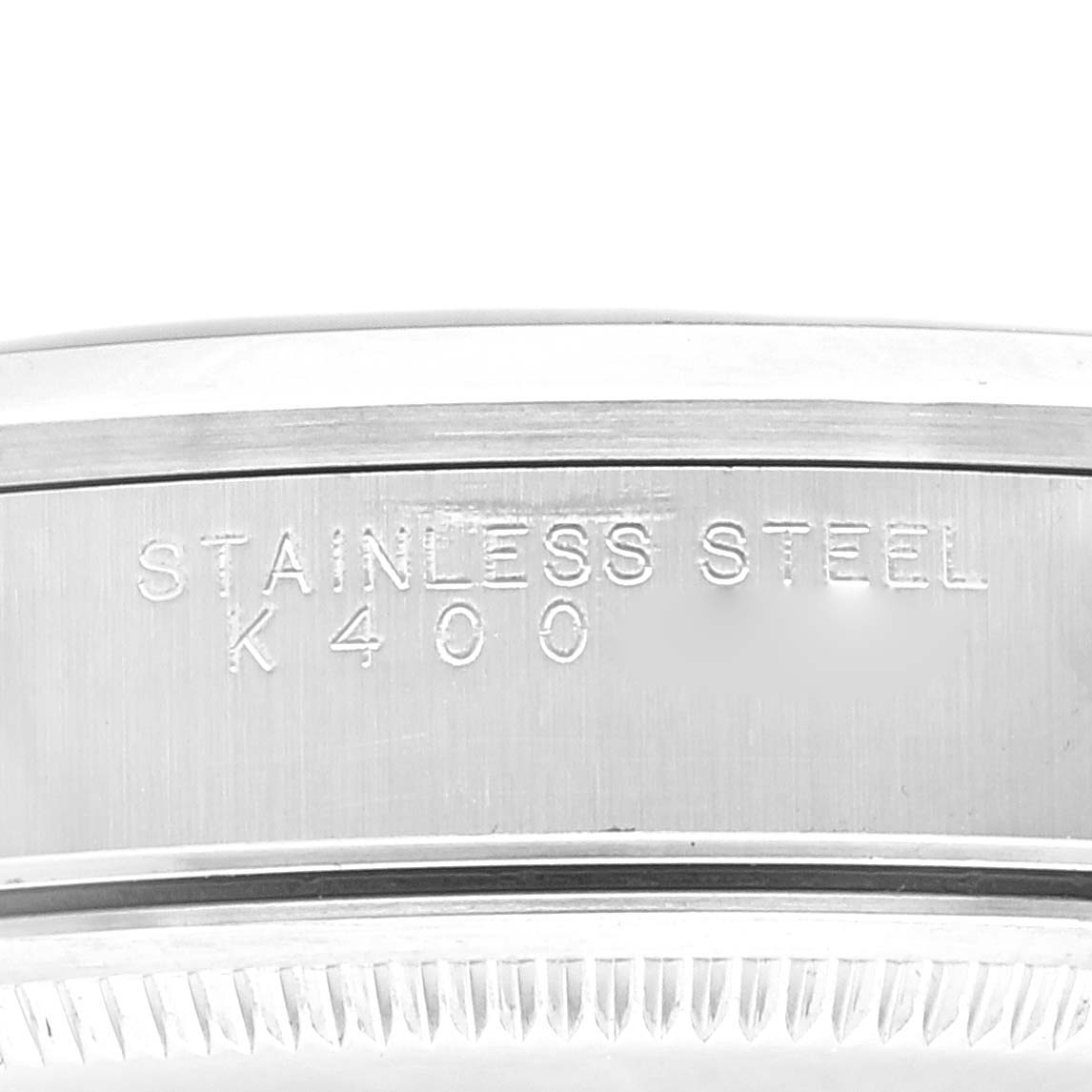 The image shows an angled close-up of the stainless steel back case of a Rolex Air-King 14000 Men's Stainless Steel Blue Dial 14000 Men's Stainless Steel Blue Dial watch, displaying its material and model number.