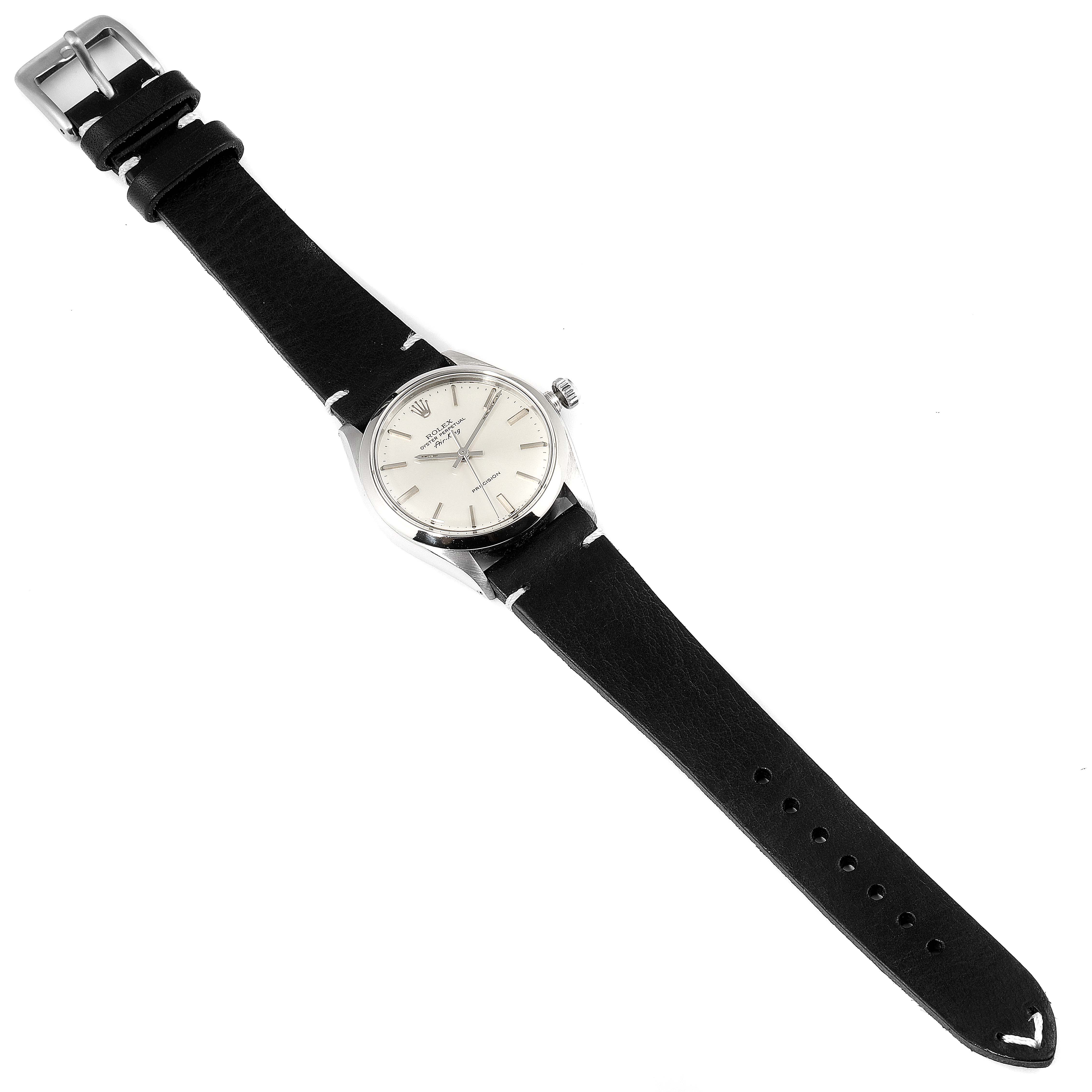 The image shows a top view of a Rolex Air-King 5500 Men's Stainless Steel Silver Dial 5500 Men's Stainless Steel Silver Dial watch with a black leather strap and a silver dial.