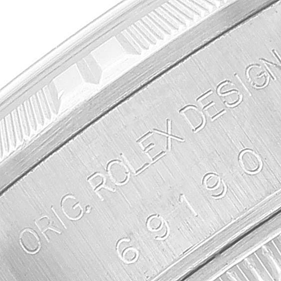 This image shows a close-up of the side casing of a Rolex Date 69190 Women's Stainless Steel Blue Dial 69190 Women's Stainless Steel Blue Dial model watch with engraved text.