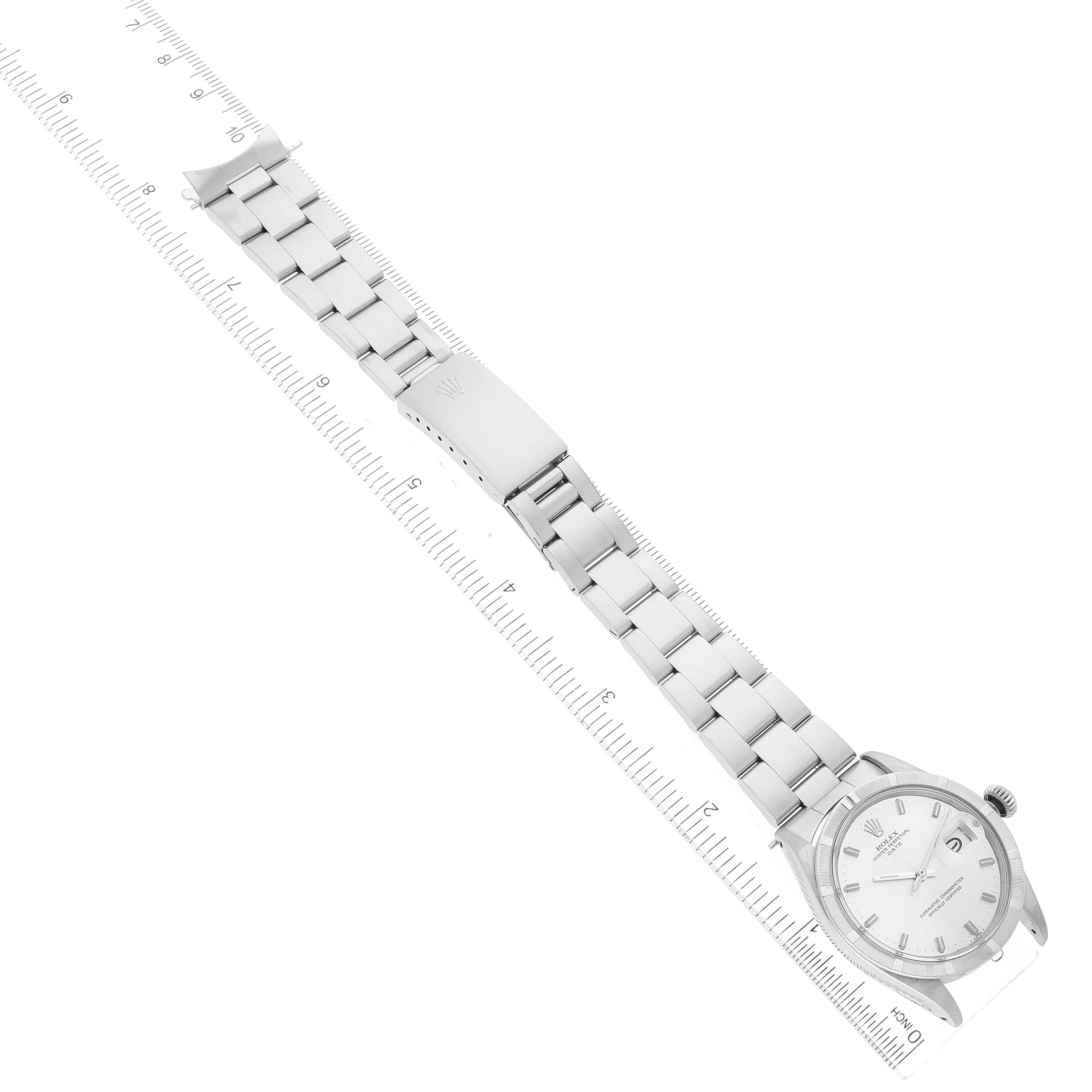 The image shows a Rolex Vintage Collection 1501 Men
s Stainless Steel Silver Dial 1501 Men
s Stainless Steel Silver Dial watch laid flat, displaying the entire watchband and watch face, with rulers for scale.