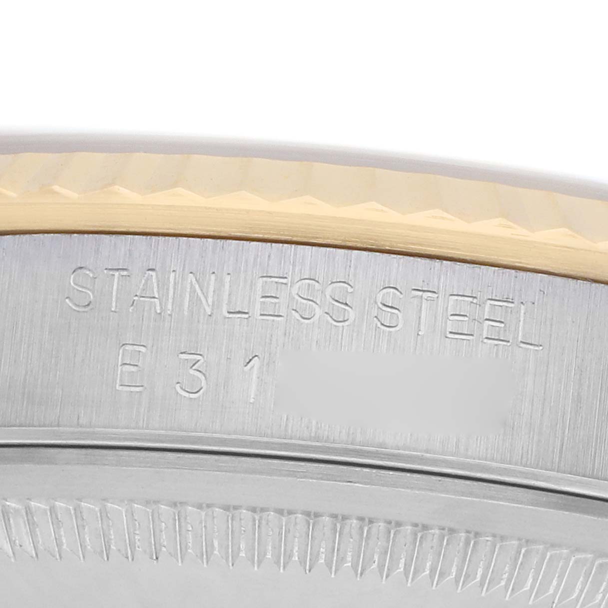 This image shows a close-up of the stainless steel bezel edge of a Rolex Datejust 16233 Men
s Steel and Gold (two tone) Champagne Dial watch, highlighting engraved markings.