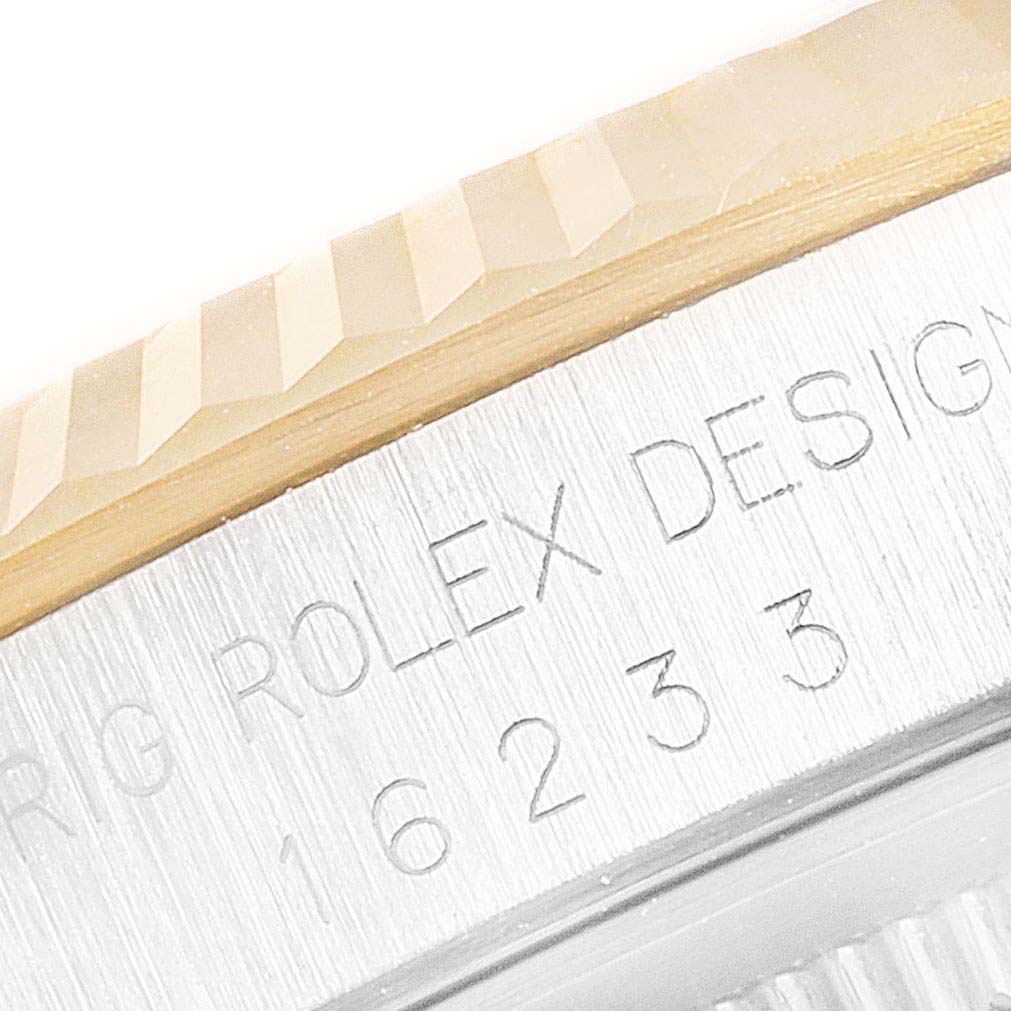 The image shows a close-up of the engraved case and fluted bezel of the Rolex Datejust 16233 Men
s Steel and Gold (two tone) Champagne Dial 16233 Men
s Steel and Gold (two tone) Champagne Dial model.
