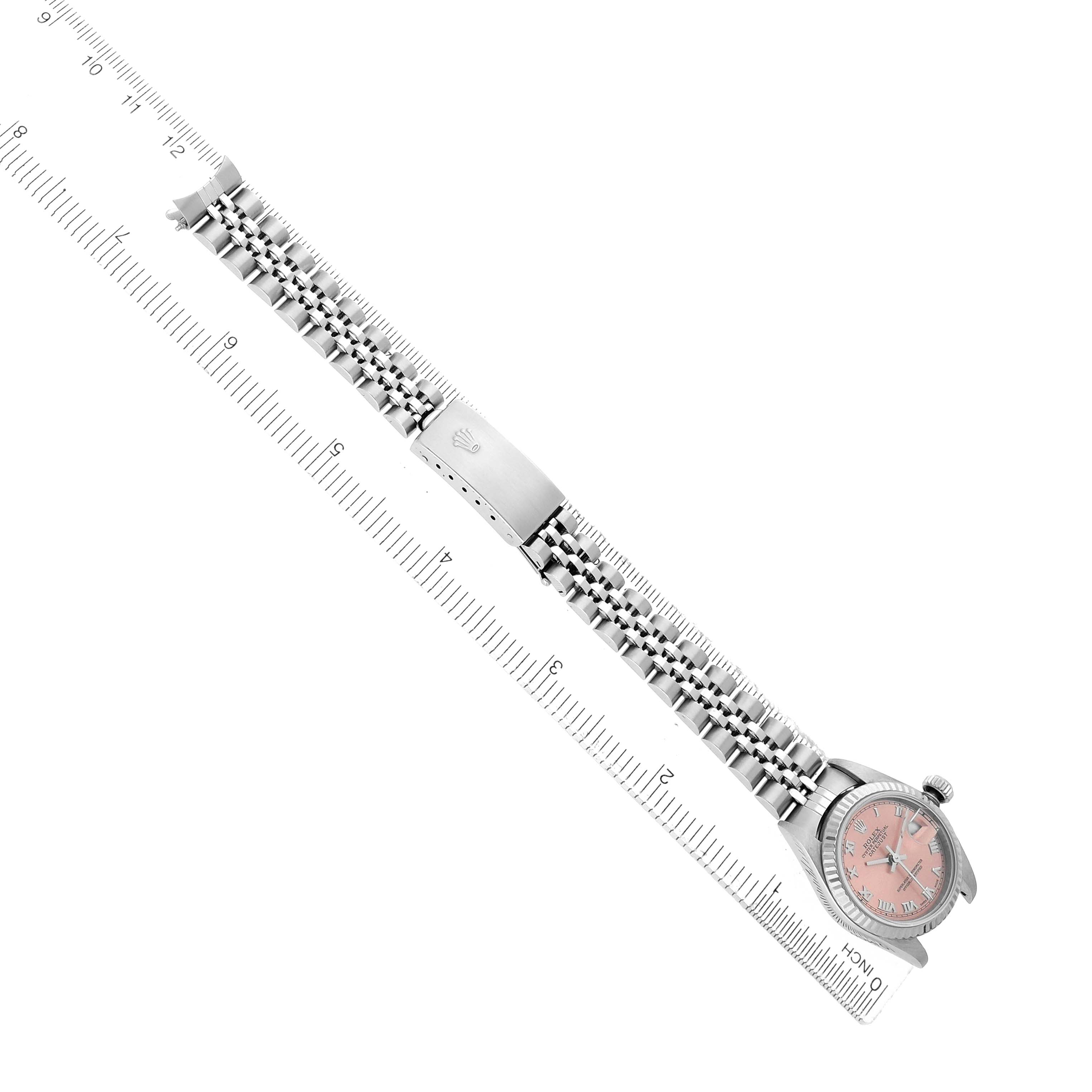 The Rolex Datejust 79174 Women
s Stainless Steel Pink Dial watch is shown from a top-down angle, featuring the face, bracelet, and clasp with a ruler for scale.