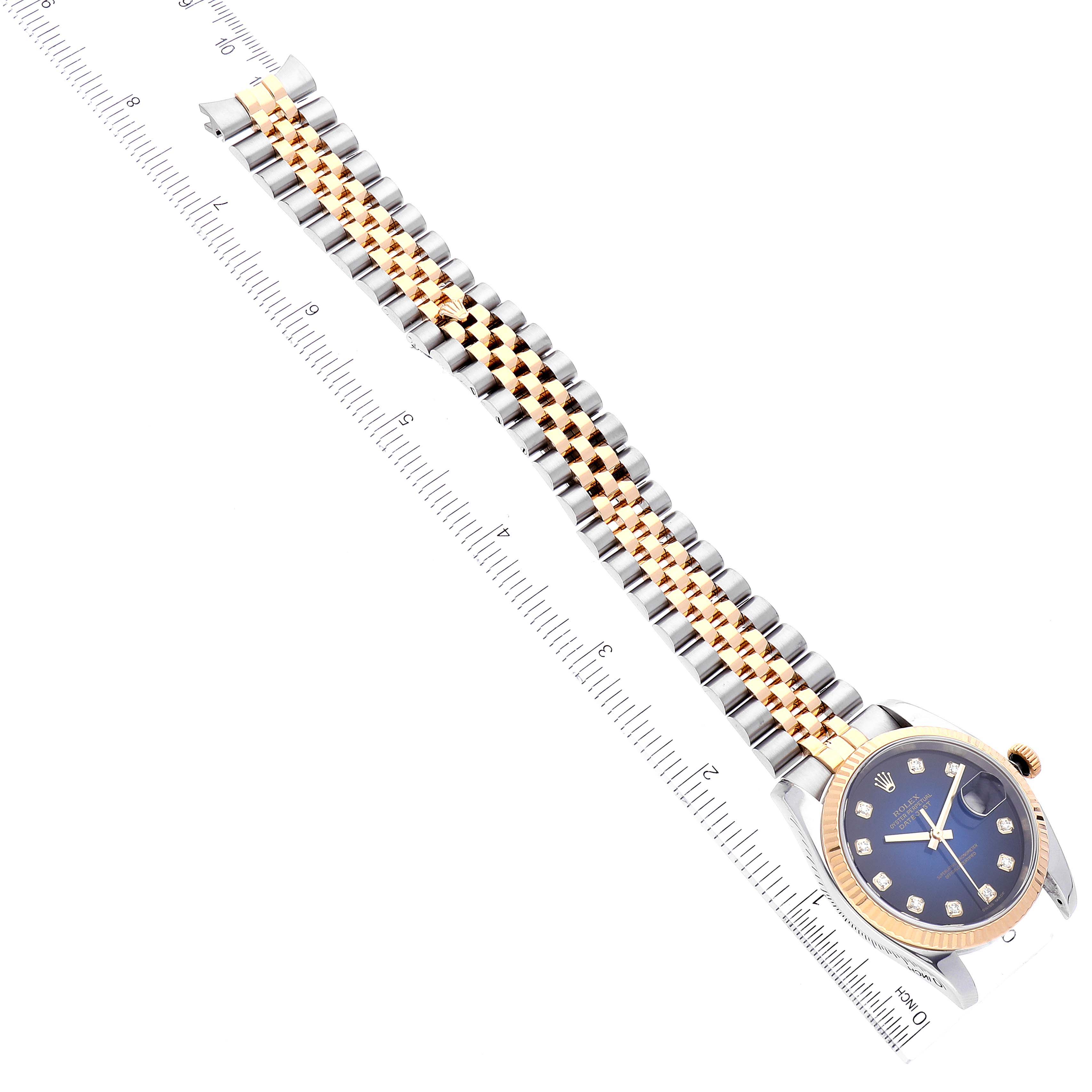 The image shows a Rolex Datejust 116233 Men's Steel and Gold (two tone) Blue Dial 116233 Men's Steel and Gold (two tone) Blue Dial watch from an angled top-down perspective, displaying the bracelet, dial, bezel, and ruler for scale.