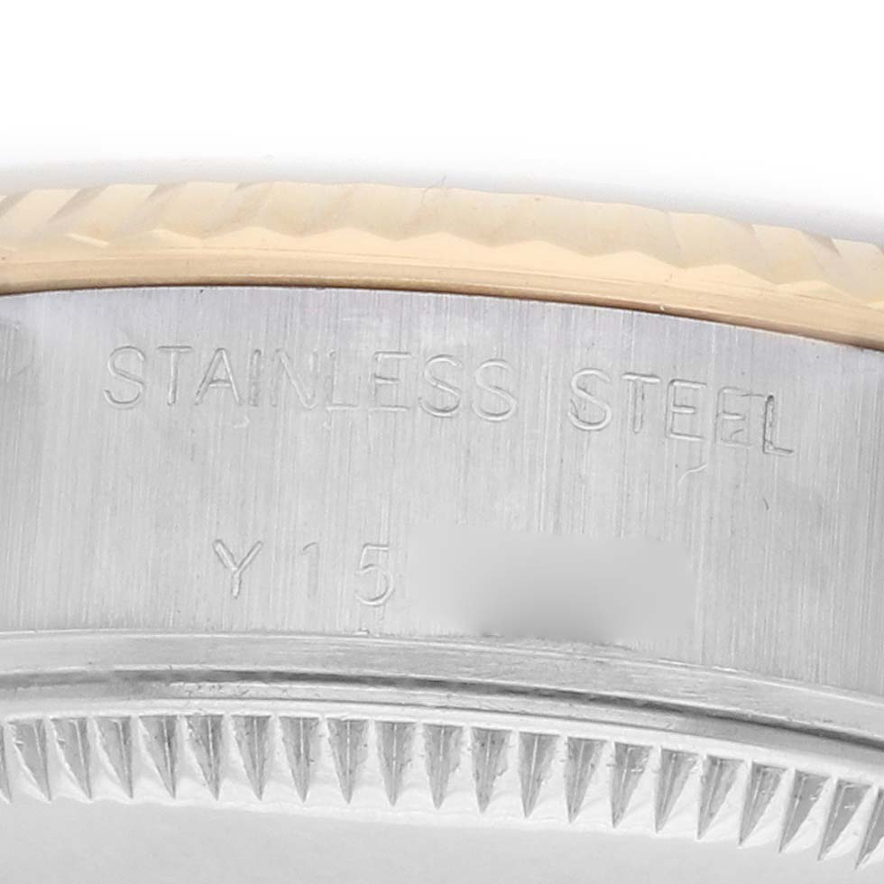 The image shows a close-up of the side of a Rolex Datejust 79173 Women
s Steel and Gold (two tone) Champagne Dial watch case, highlighting the stainless steel material and part of the fluted bezel.