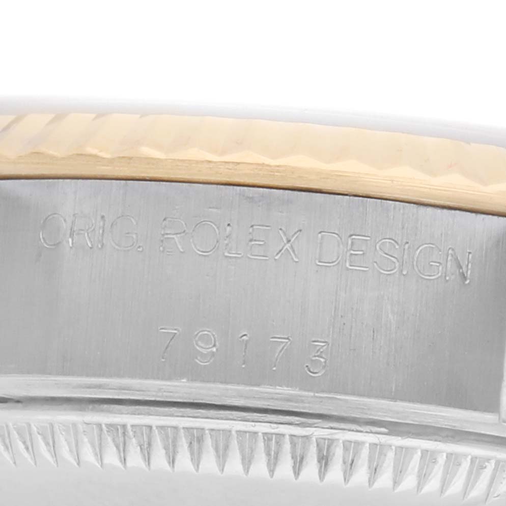 The image shows a close-up side view of the Rolex Datejust 79173 Women
s Steel and Gold (two tone) Champagne Dial
s case, highlighting the model number and "Orig. Rolex Design" engraving.