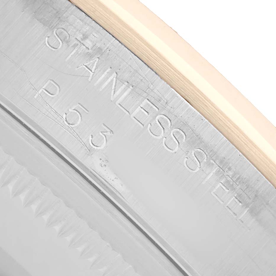 The image shows a close-up of the edge and engraving on the bezel of a Rolex Datejust 16203 Men
s Steel and Gold (two tone) Silver Dial watch, highlighting "STAINLESS STEEL" text.