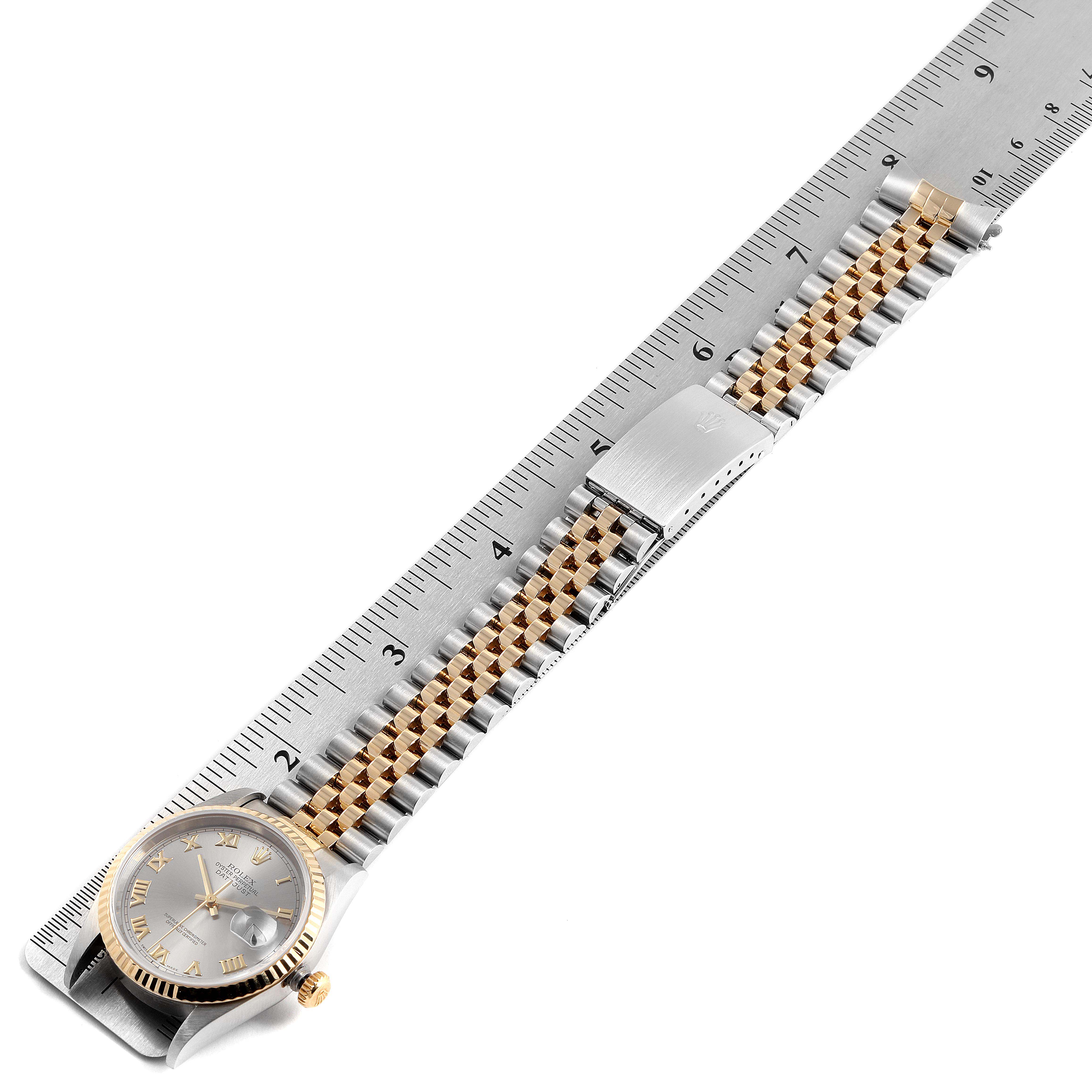 The Rolex Datejust 16233 Men's Steel and Gold (two tone) Grey Dial 16233 Men's Steel and Gold (two tone) Grey Dial watch is shown from a top-down angle, highlighting the dial, bracelet, and clasp along a ruler.