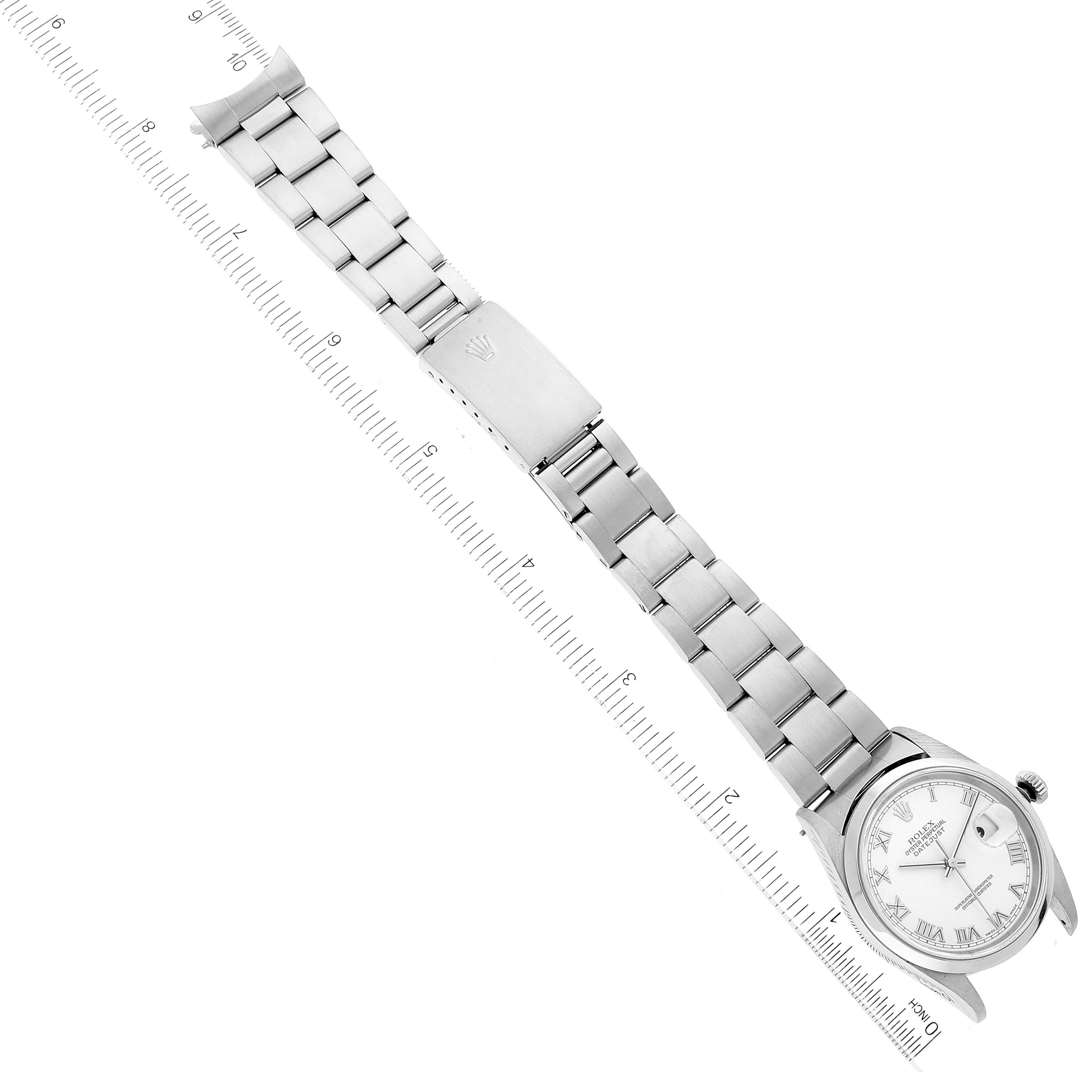 The image shows a top view of the Rolex Datejust 16200 Men's Stainless Steel White Dial 16200 Men's Stainless Steel White Dial watch, including its face, bracelet, and clasp, placed alongside a ruler.