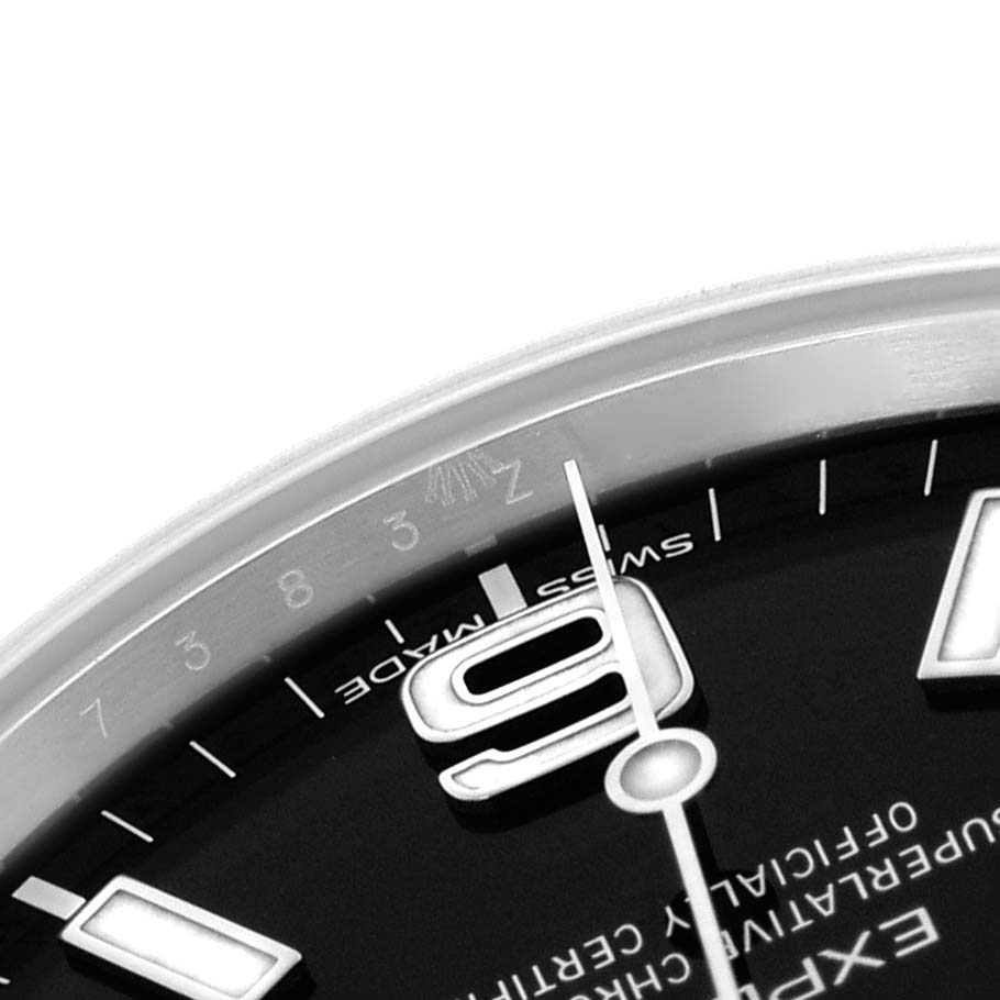 The image shows a close-up of the dial
s upper-right portion on a Rolex Explorer 214270 Men
s Stainless Steel Black Dial, highlighting the bezel and the 9 o
clock numeral.