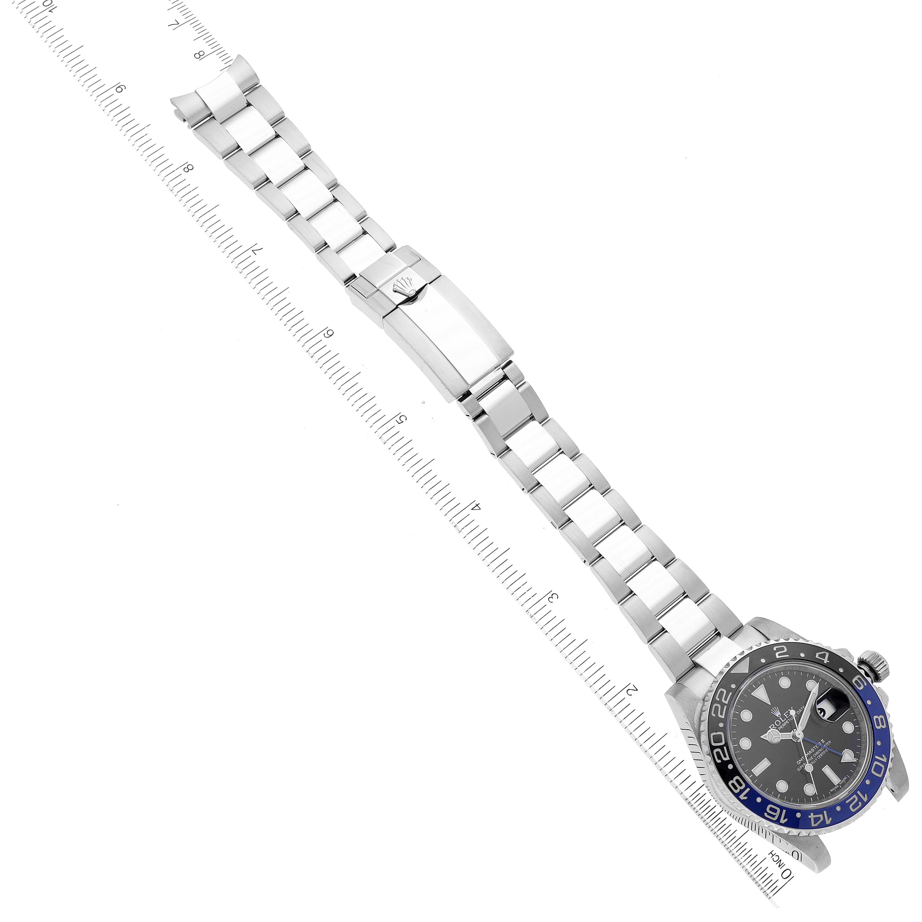 The image shows a top-down view of a Rolex GMT-Master 116710 Men
s Stainless Steel Black Dial 116710 Men
s Stainless Steel Black Dial watch, focusing on the face, bracelet, and clasp alongside a ruler.