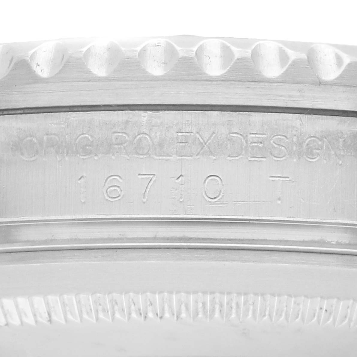 The image shows a close-up view of the engraved side of the bezel on a Rolex GMT-Master 16710 Men
s Stainless Steel Black Dial, featuring model number "16710."