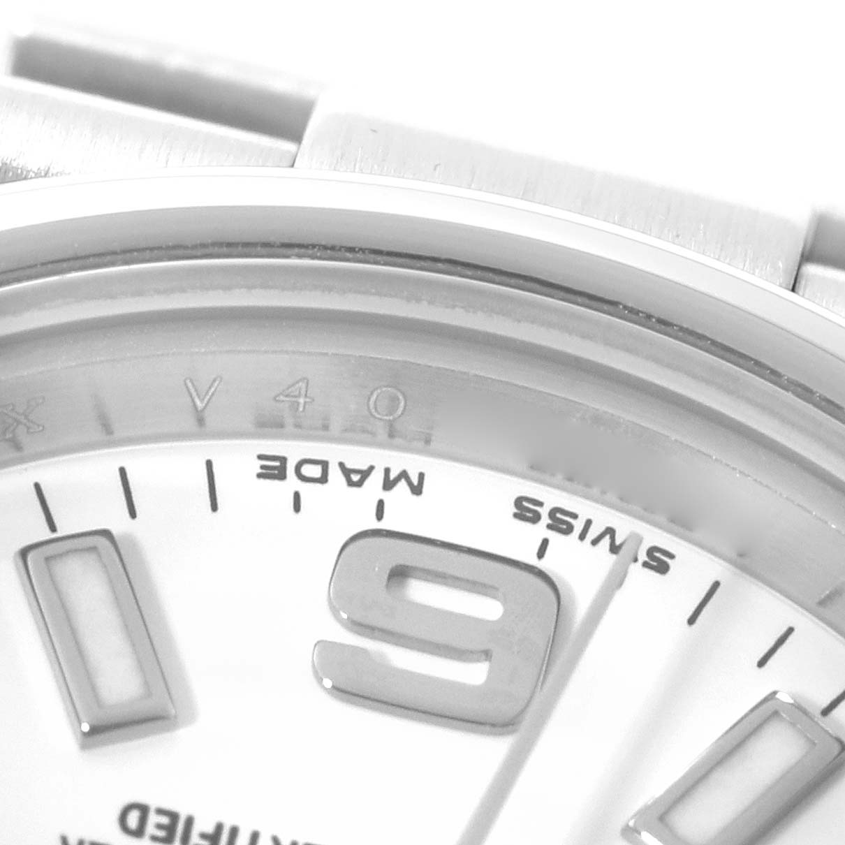 The image shows a close-up of the dial and the case of a Rolex Oyster Perpetual 176200 Women's Stainless Steel White Dial 176200 Women's Stainless Steel White Dial watch, focusing on the "9" numeral and parts of the "Swiss Made" text.