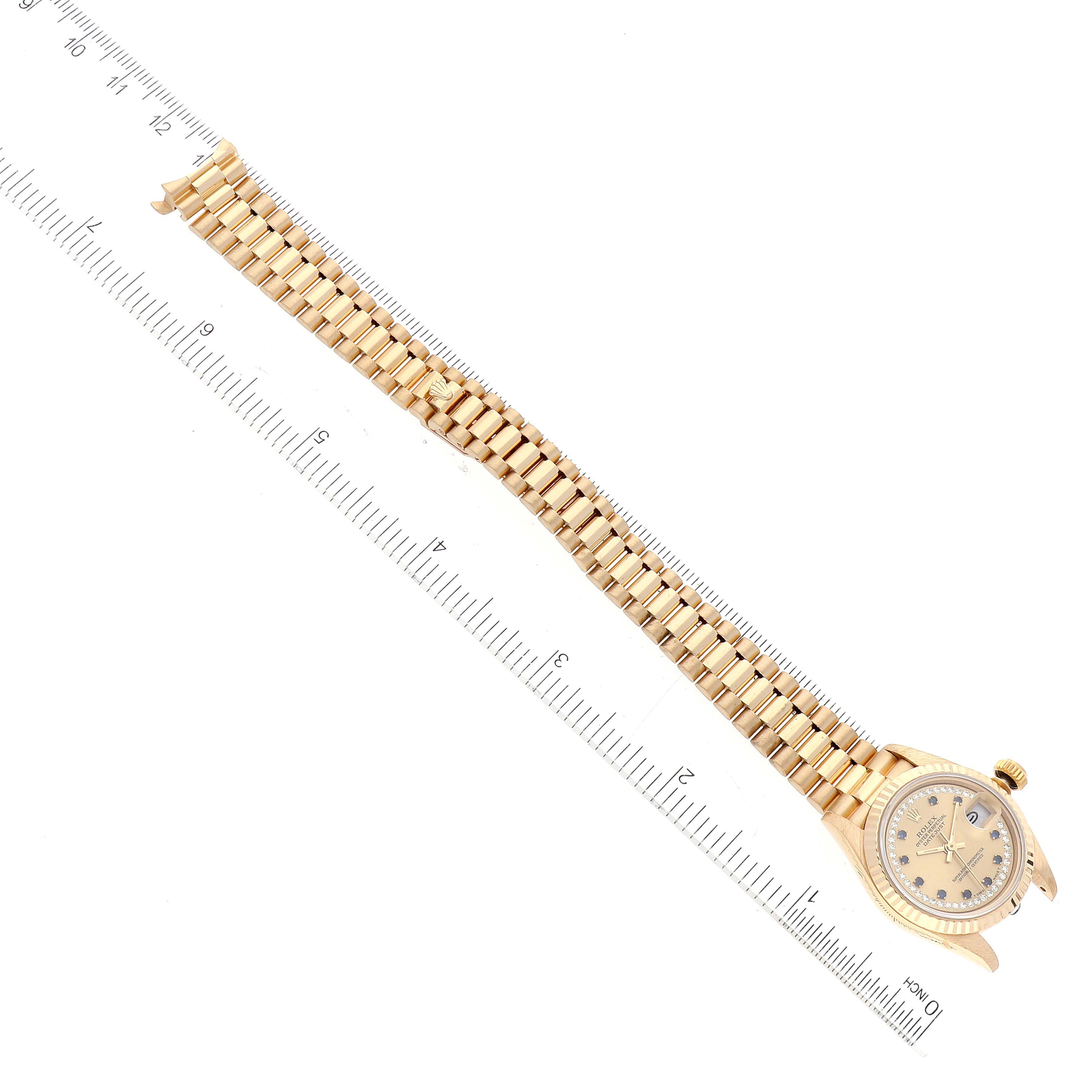 The image shows a Rolex President 69178 Women
s Yellow Gold Champagne Dial 69178 Women
s Yellow Gold Champagne Dial model watch lying flat, with a ruler for measurement next to it.