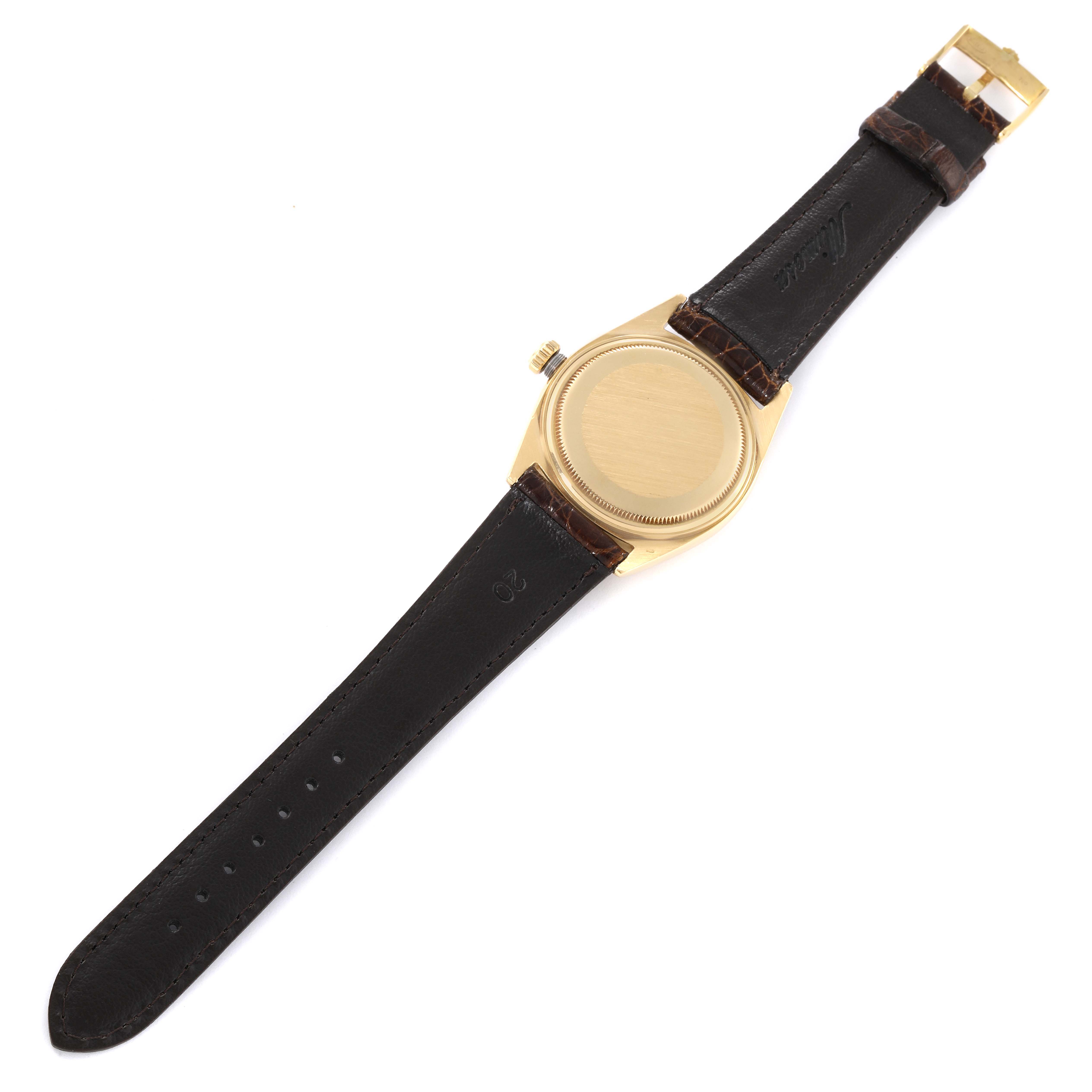 The image shows the back view of a Rolex Vintage Collection 1803 Men's Yellow Gold Silver Dial 1803 Men's Yellow Gold Silver Dial watch featuring a gold case and black leather strap.