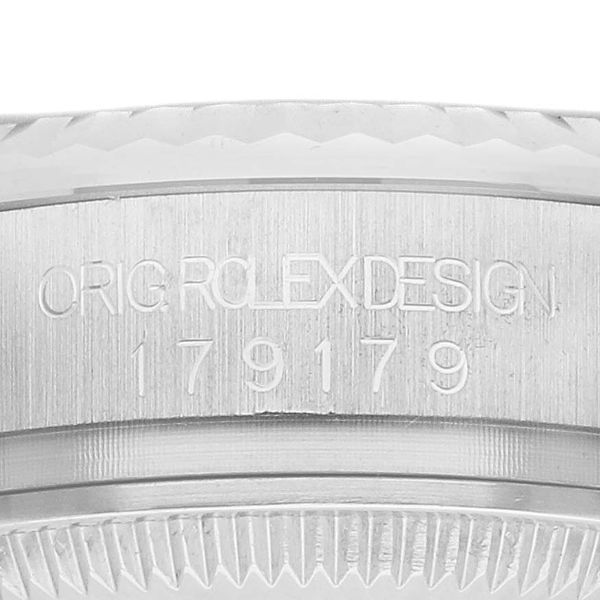 The image shows the side view of the Rolex President 179179 Women
s White Gold Silver Dial model, focusing on the engraved watch case and serial number.