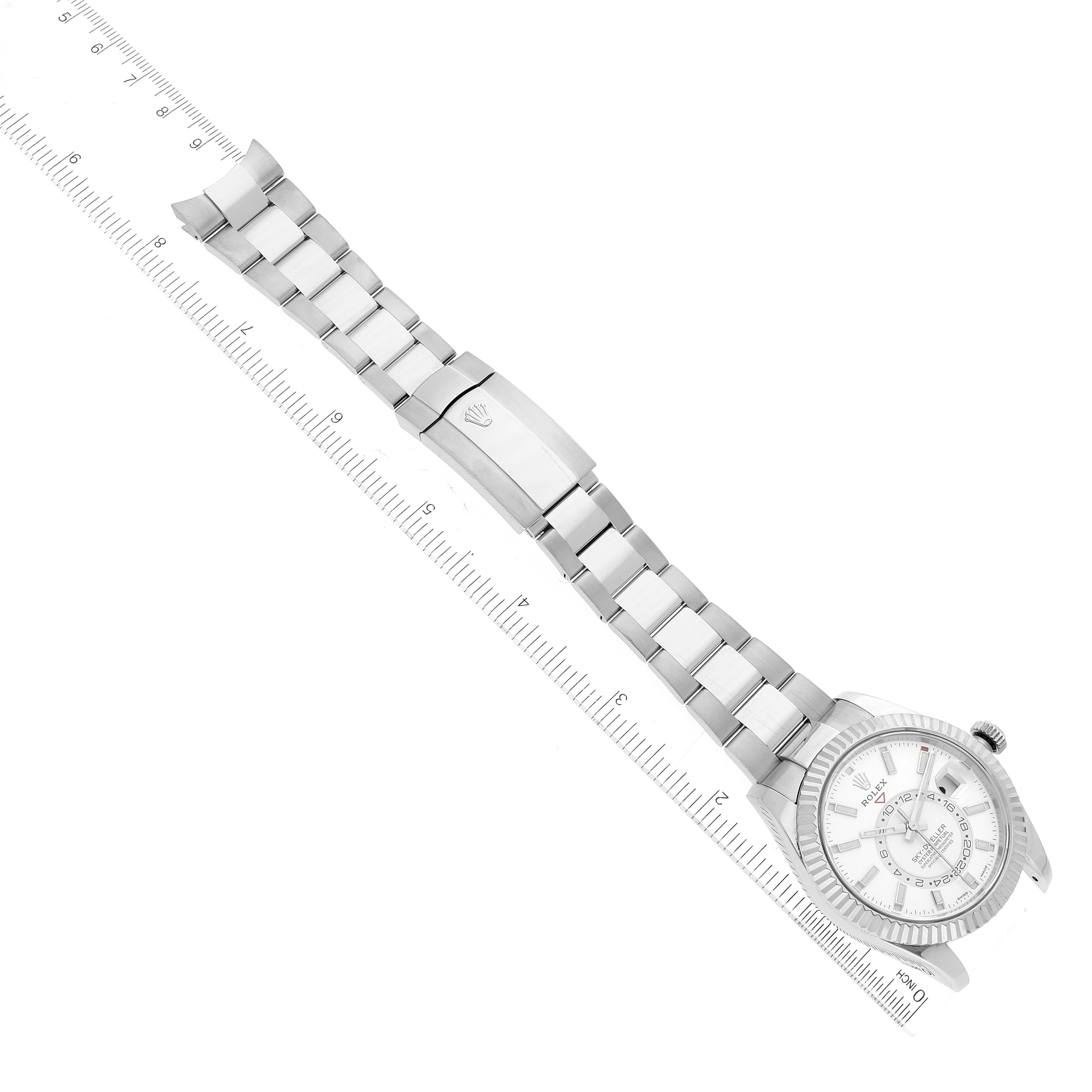 The image shows a Rolex Sky-Dweller 326934 Men's Stainless Steel White Dial 326934 Men's Stainless Steel White Dial watch lying flat with its bracelet extended and a ruler beside it for measurement.