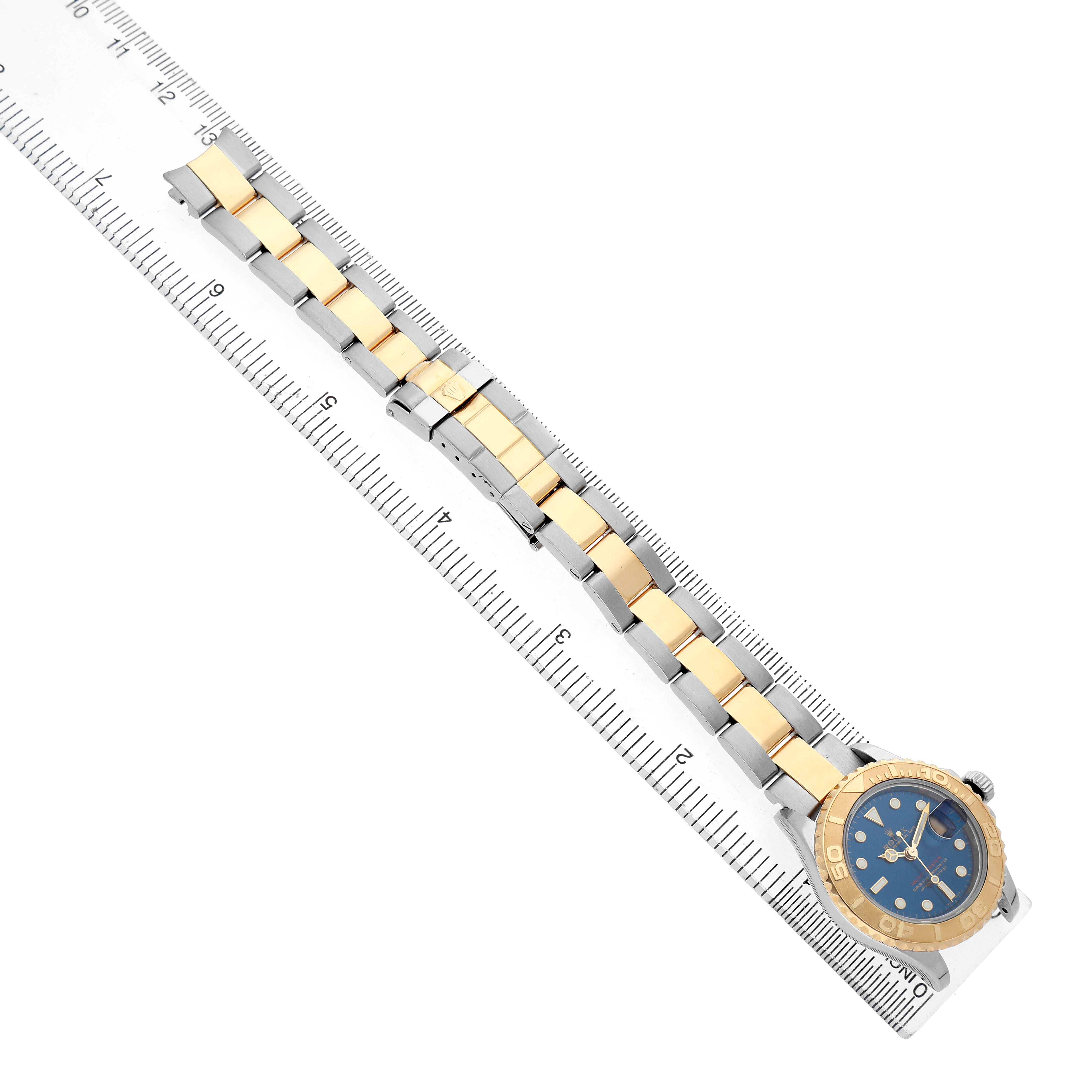 The Rolex Yacht-Master 169623 Women's Steel and Gold (two tone) Blue Dial watch is shown flat, highlighting the bracelet and case with a ruler for scale.