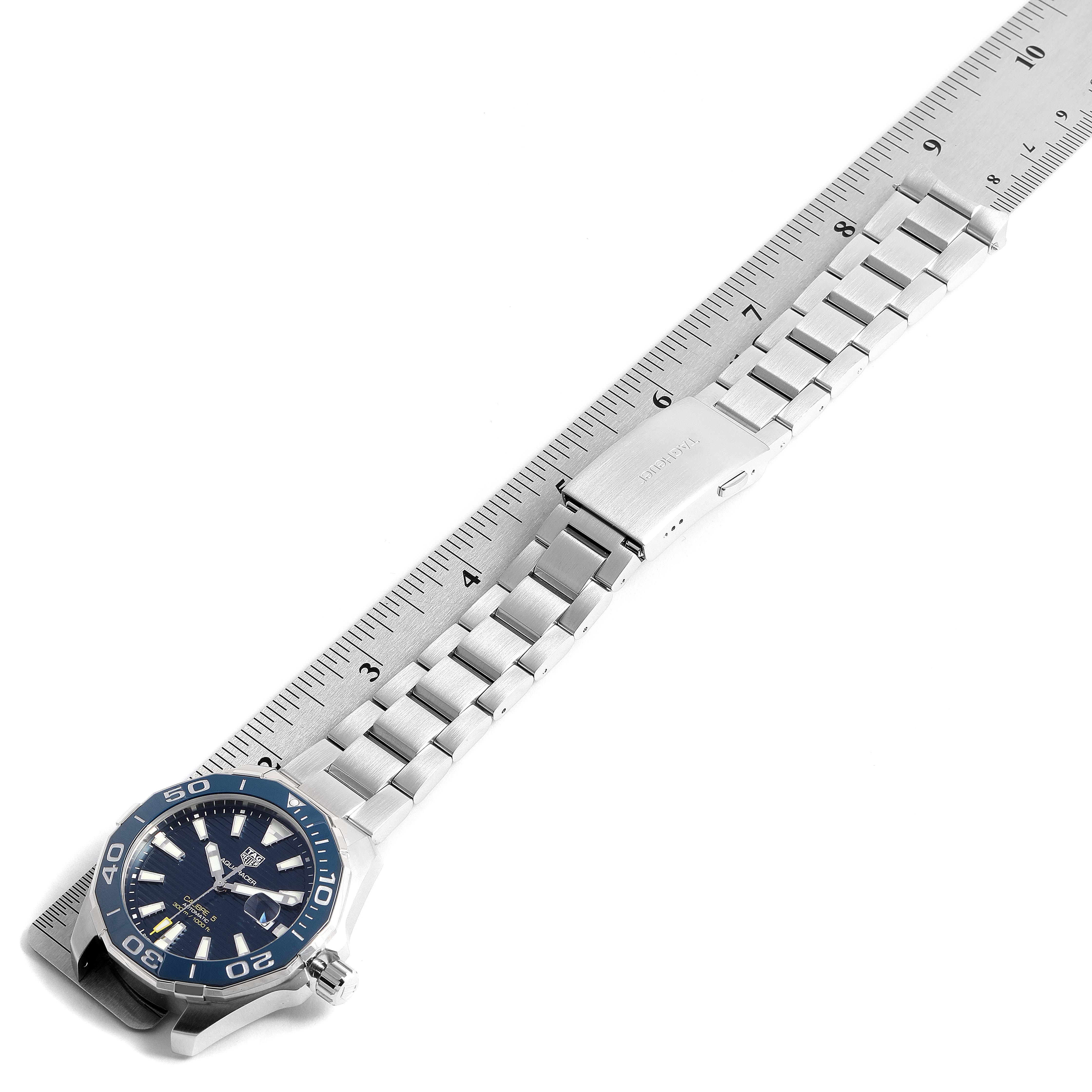 The image shows a Tag Heuer Aquaracer WAY201B Men
s Stainless Steel Blue Dial WAY201B Men
s Stainless Steel Blue Dial watch, with the band laid flat against a ruler and the face angled slightly up.
