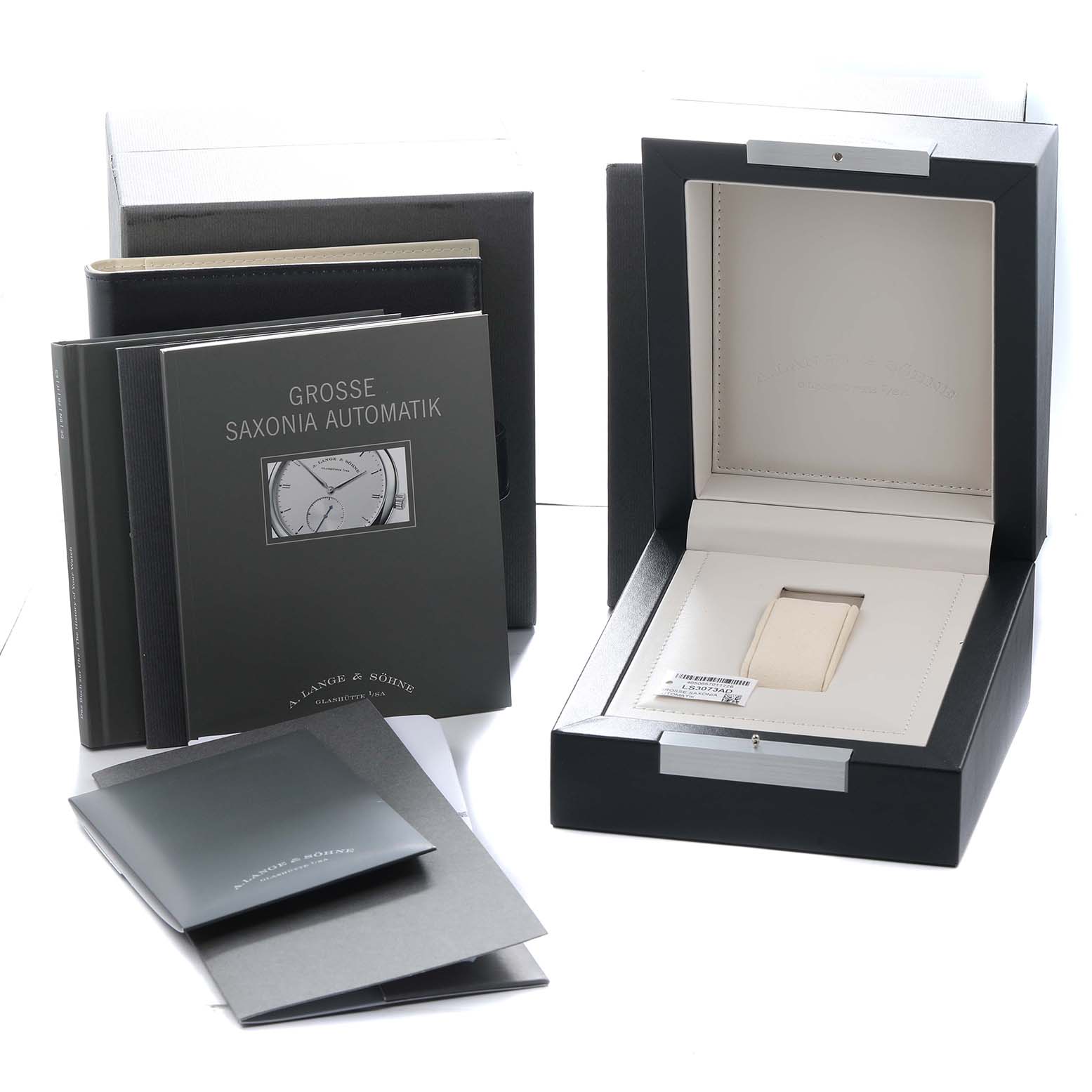 The image shows an open A. Lange 
Sohne Saxonia 307.029 Men
s White Gold Black Dial watch box and manuals, with the box positioned at a slight angle.