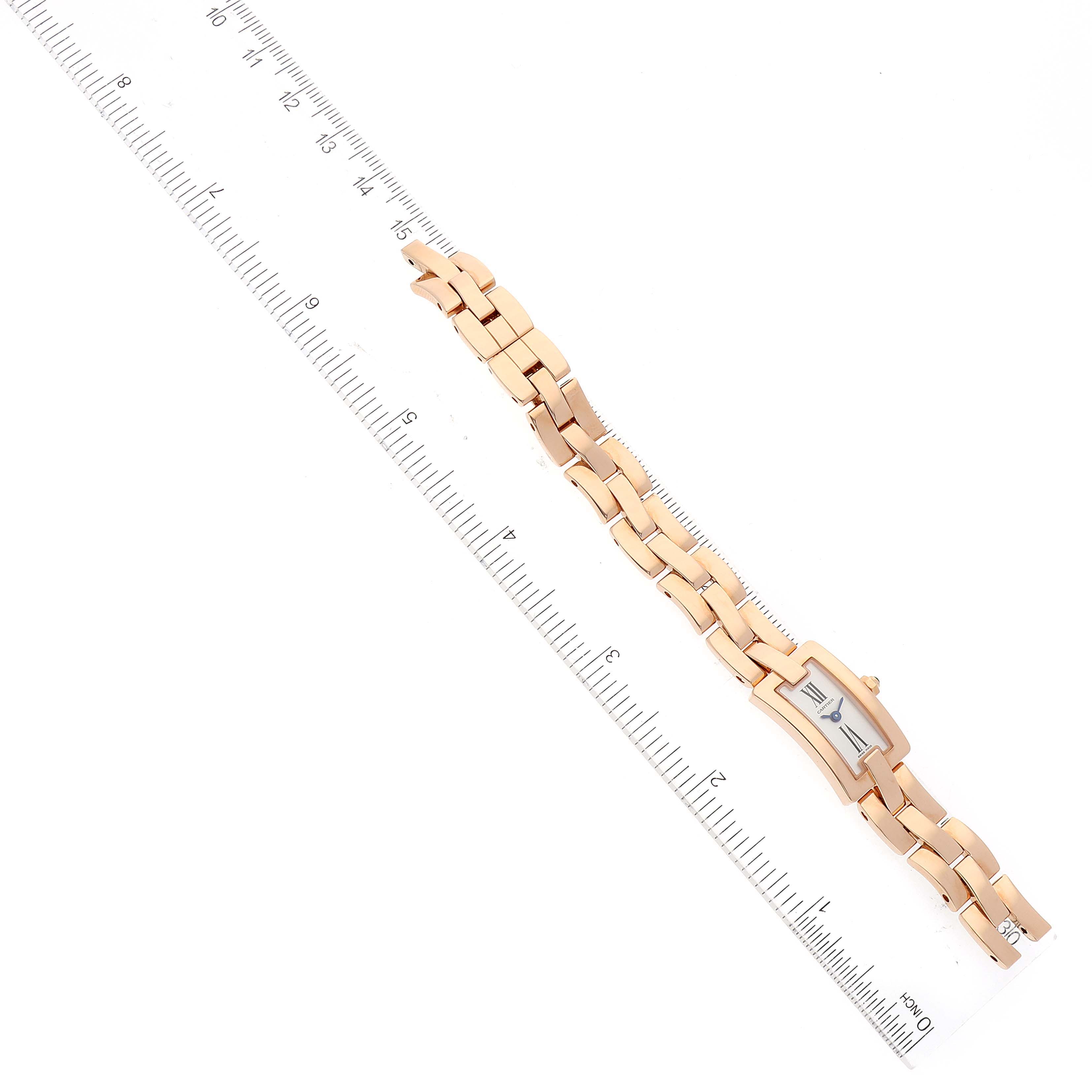 The image shows an overhead view of the Cartier Balerina W700023J Women's Rose Gold Silver Dial W700023J Women's Rose Gold Silver Dial watch, including its bracelet and face, next to a ruler for scale.