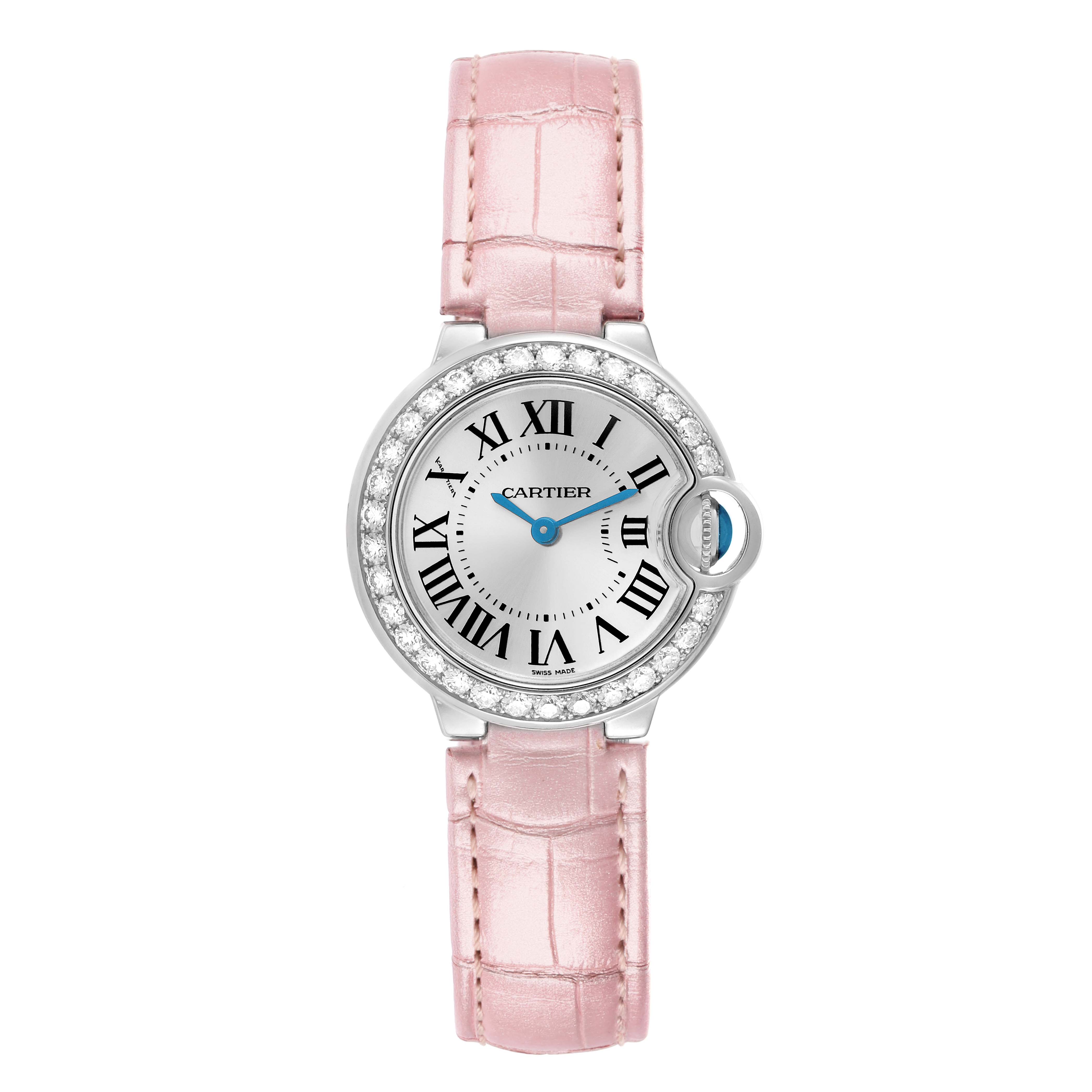 The Cartier Ballon Bleu WE900351 Women
s White Gold Silver Dial watch is shown from a top-down angle, featuring a pink strap and a diamond-studded bezel.
