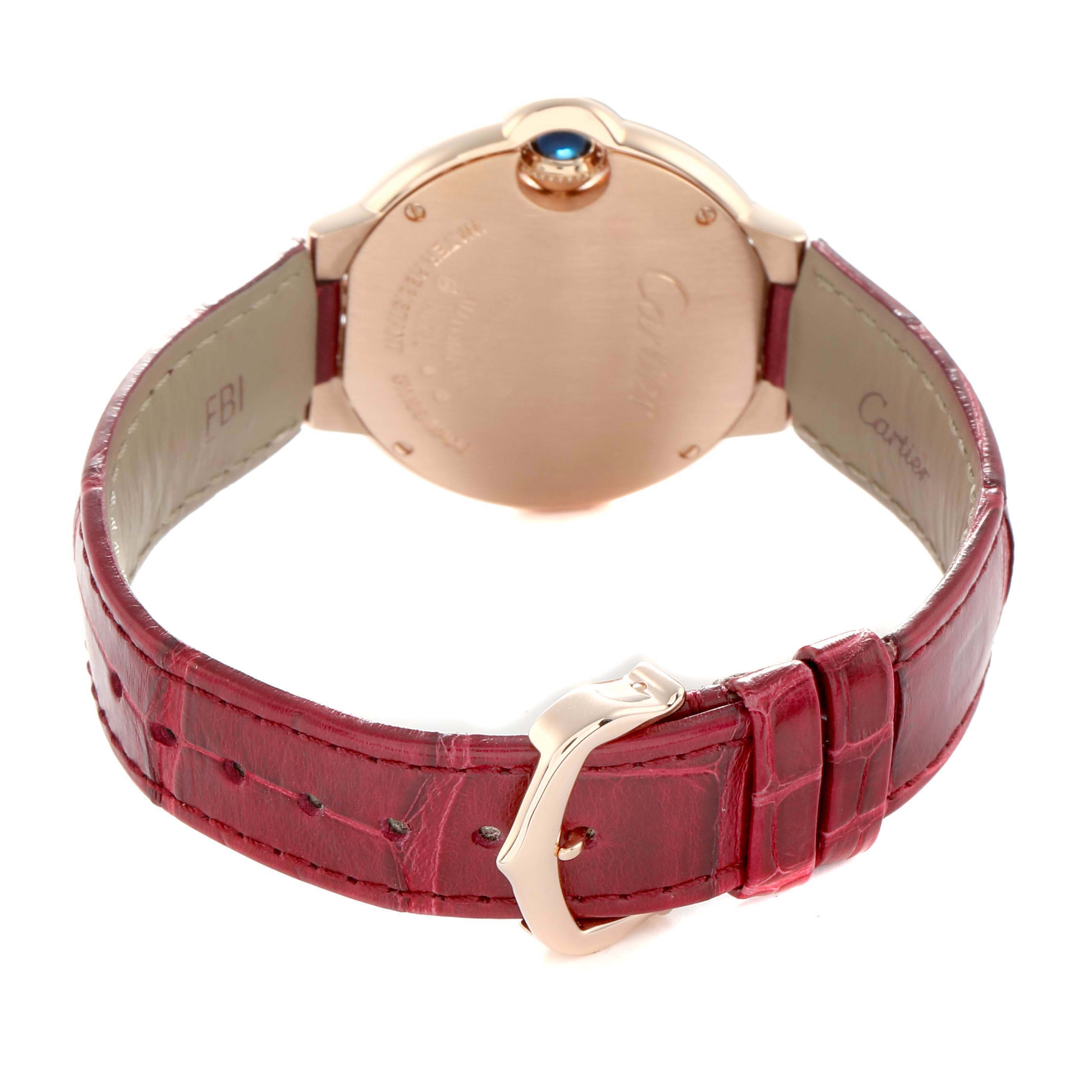 The image shows the back view of the Cartier Ballon Bleu WJBB0080 Women's Rose Gold Silver Dial watch, highlighting its case, crown, and red strap with buckle.