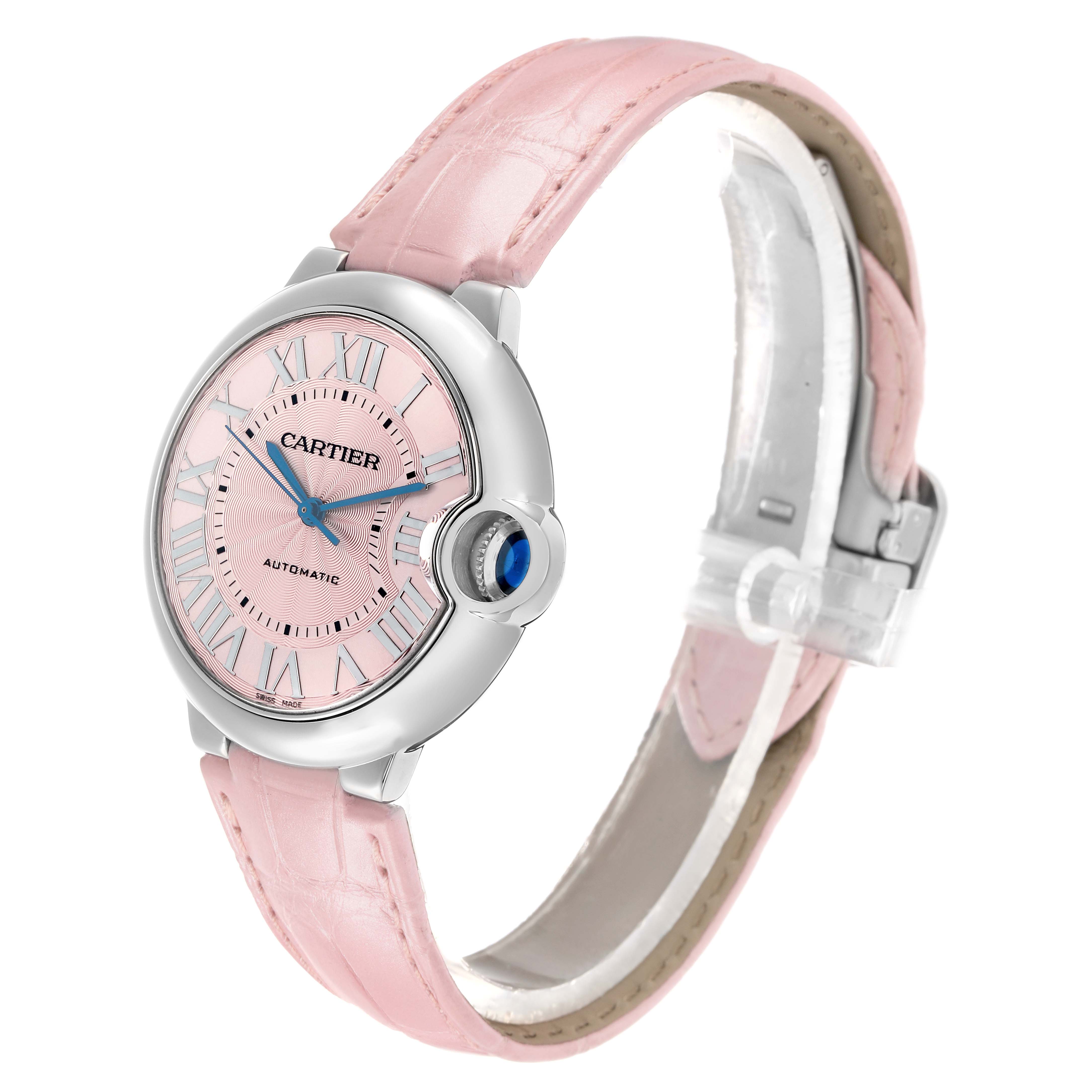 The Cartier Ballon Bleu WSBB0007 Women
s Stainless Steel Pink Dial watch is shown at a three-quarter angle, highlighting its round case and pink strap.