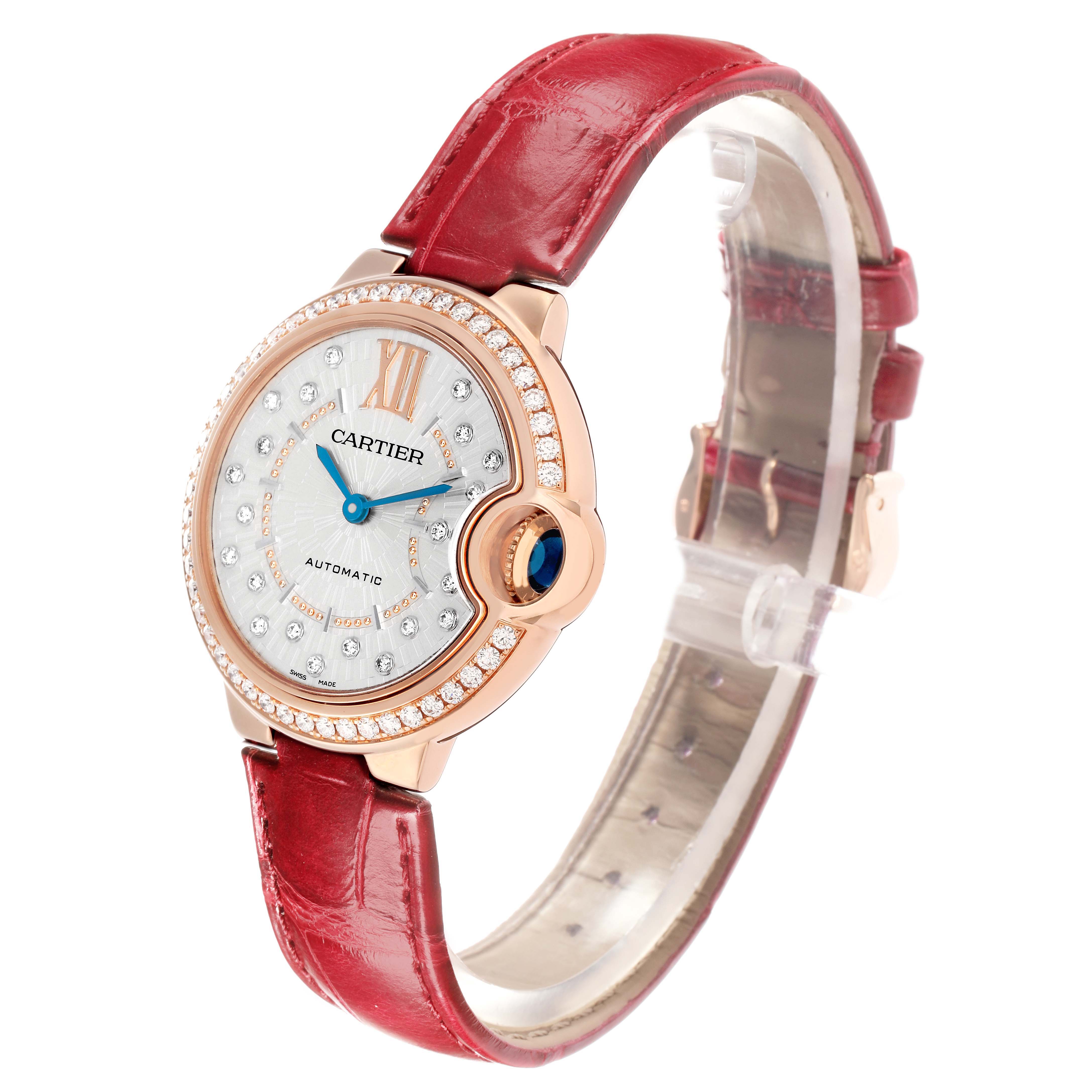 The Cartier Ballon Bleu WJBB0080 Women
s Rose Gold Silver Dial watch is shown at an angled side view, highlighting the round case, diamond bezel, and red leather strap.