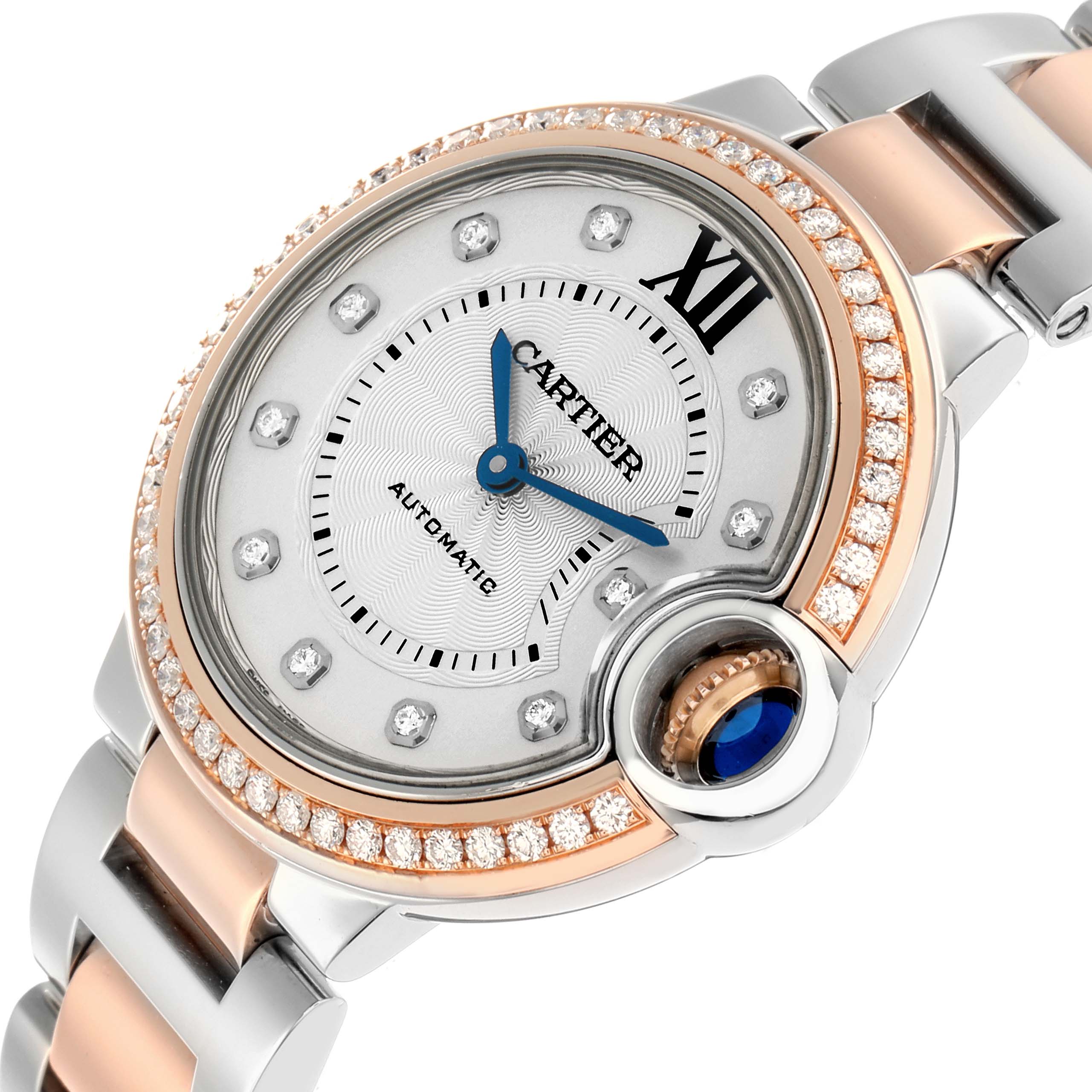 The Cartier Ballon Bleu WE902077 Women
s Steel and Gold (two tone) Silver Dial watch is shown at an angle highlighting the face, diamond bezel, crown, and part of the bracelet.