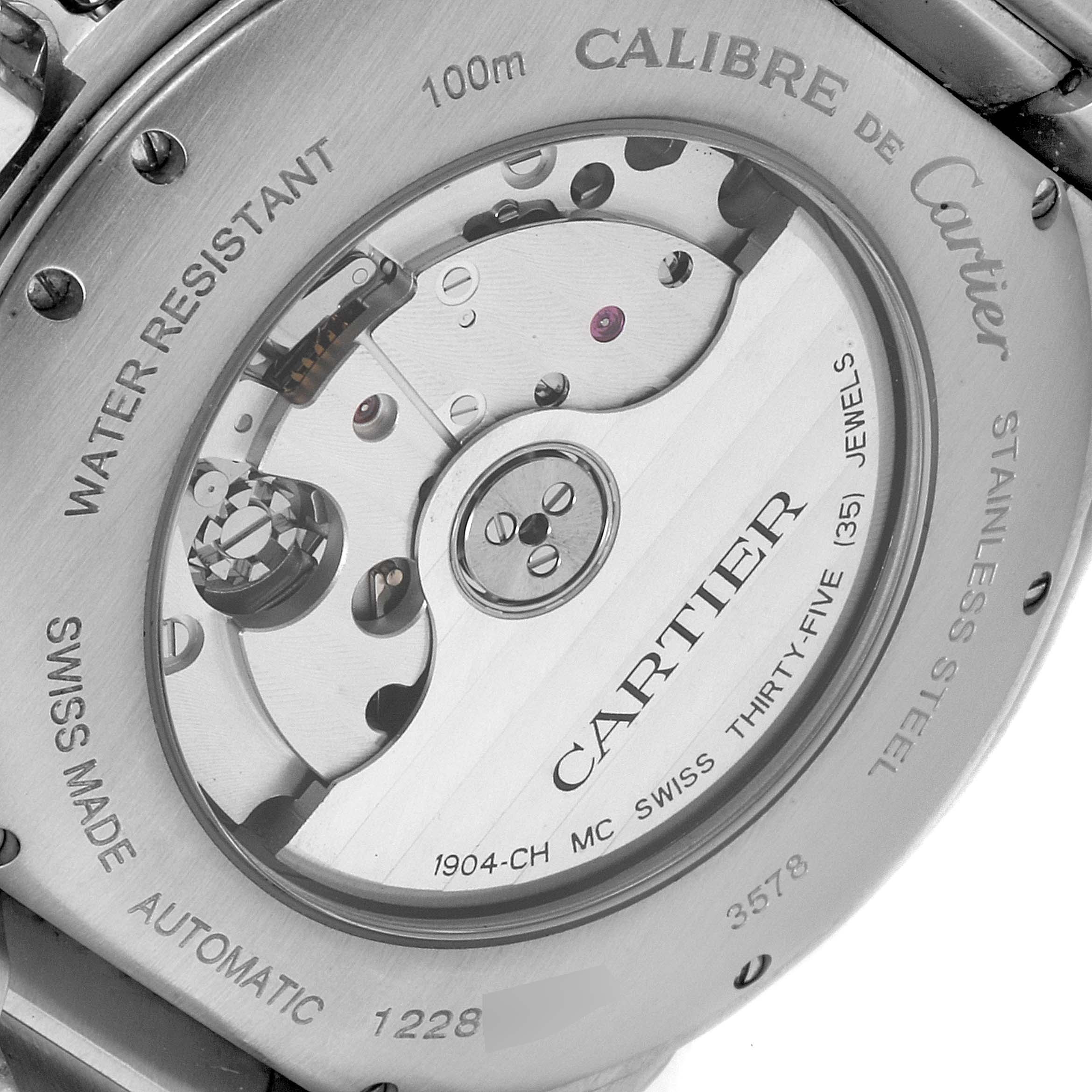 The image shows the back of a Calibre de Cartier watch, showcasing its automatic movement and engraving details.