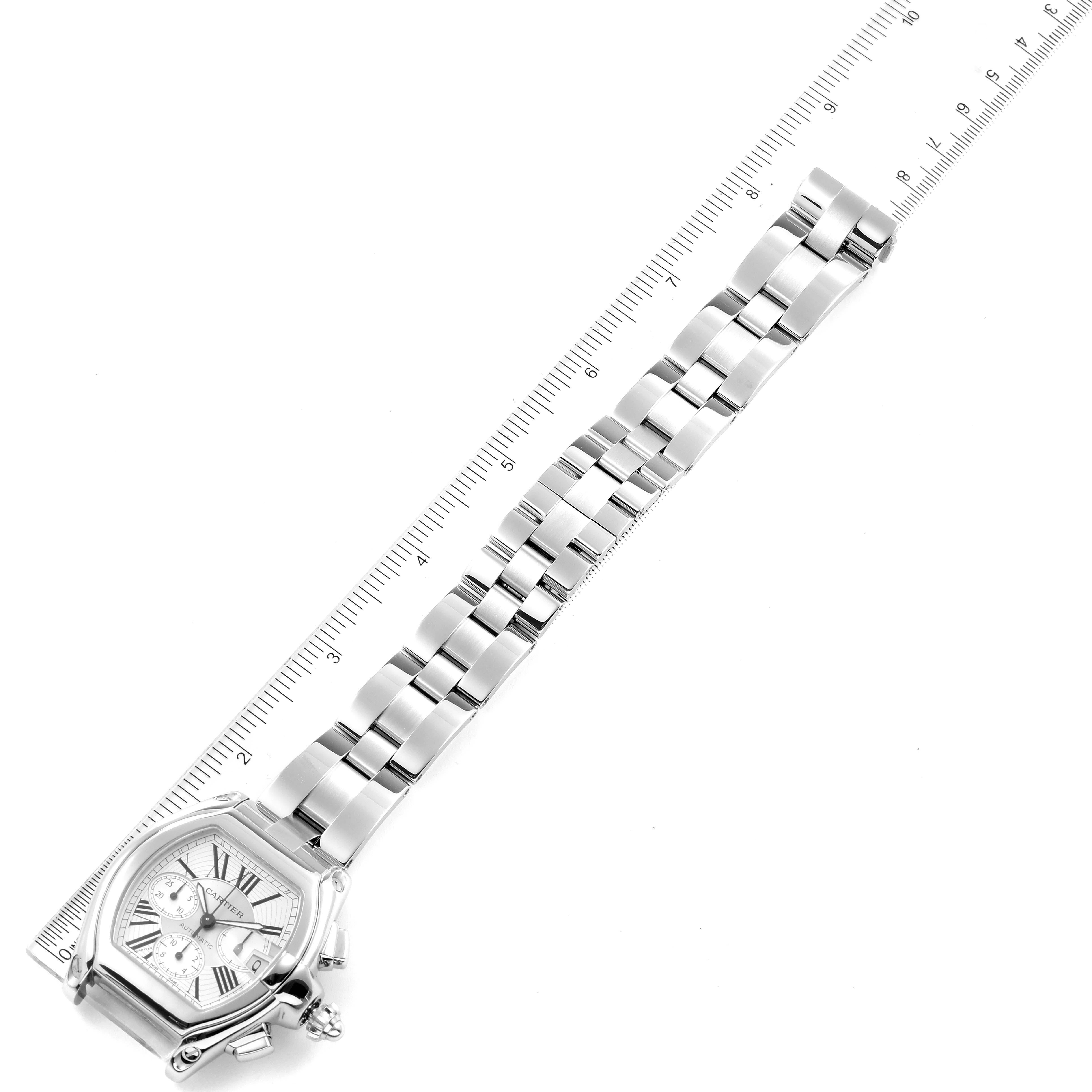 The image shows a Cartier Roadster W62019X6 Men
s Stainless Steel Silver Dial W62019X6 Men
s Stainless Steel Silver Dial watch laid flat with its stainless steel bracelet alongside a ruler for scale.
