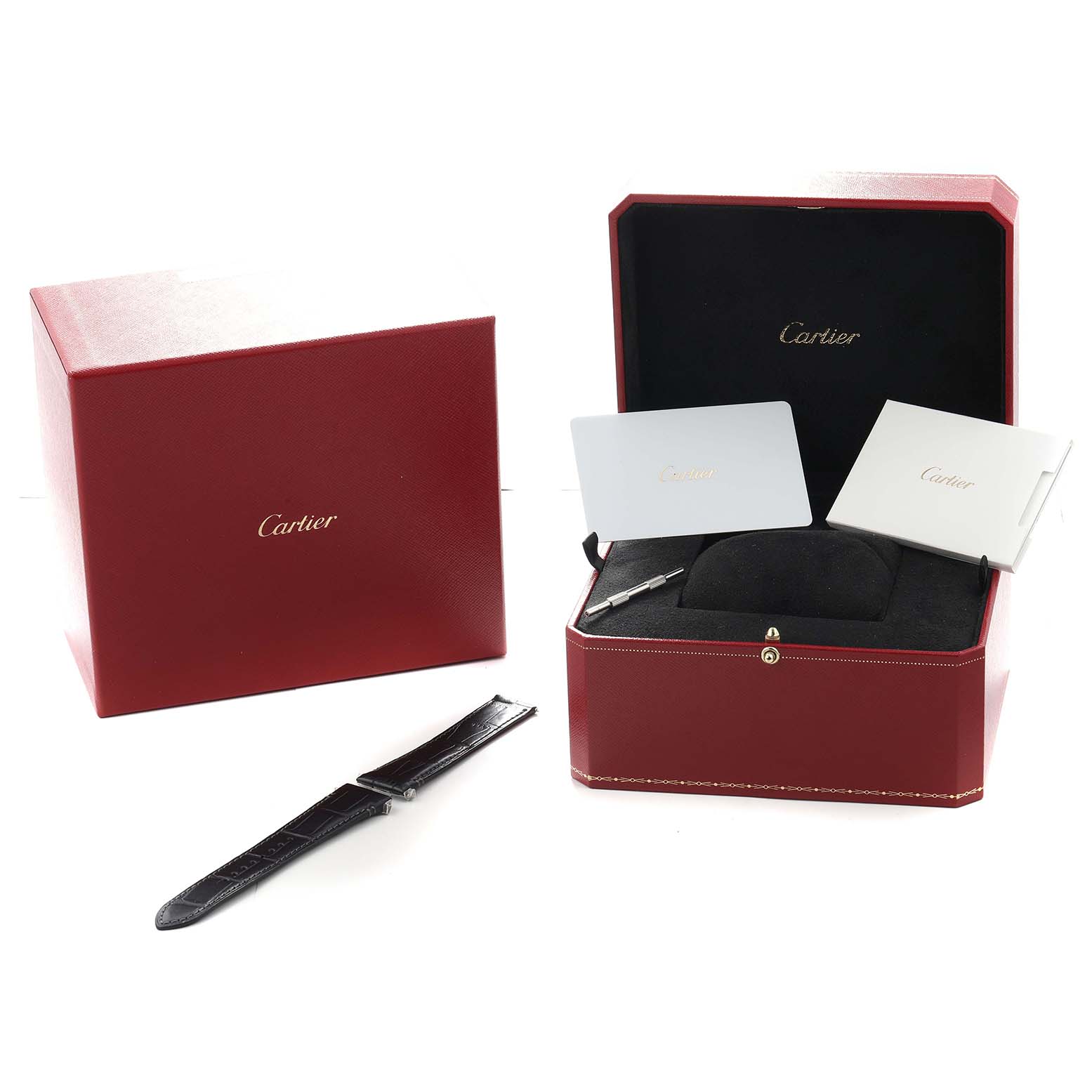 The image shows a Cartier Santos Dumont WSSA0039 Men
s Stainless Steel Black Dial watch box with manuals, a strap, and a tool, viewed from a front angle.