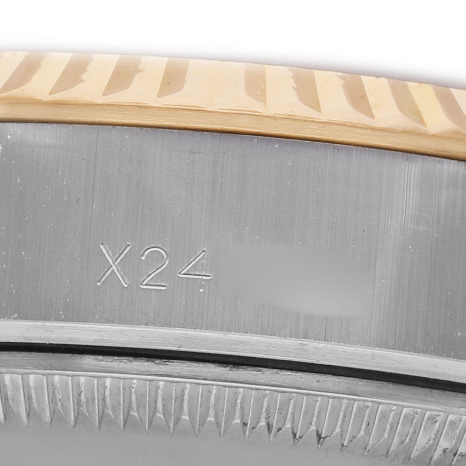 The image shows a close-up of the fluted bezel and part of the case of a Rolex Datejust 69173 Women's Steel and Gold (two tone) Champagne Dial, with some engravings visible.