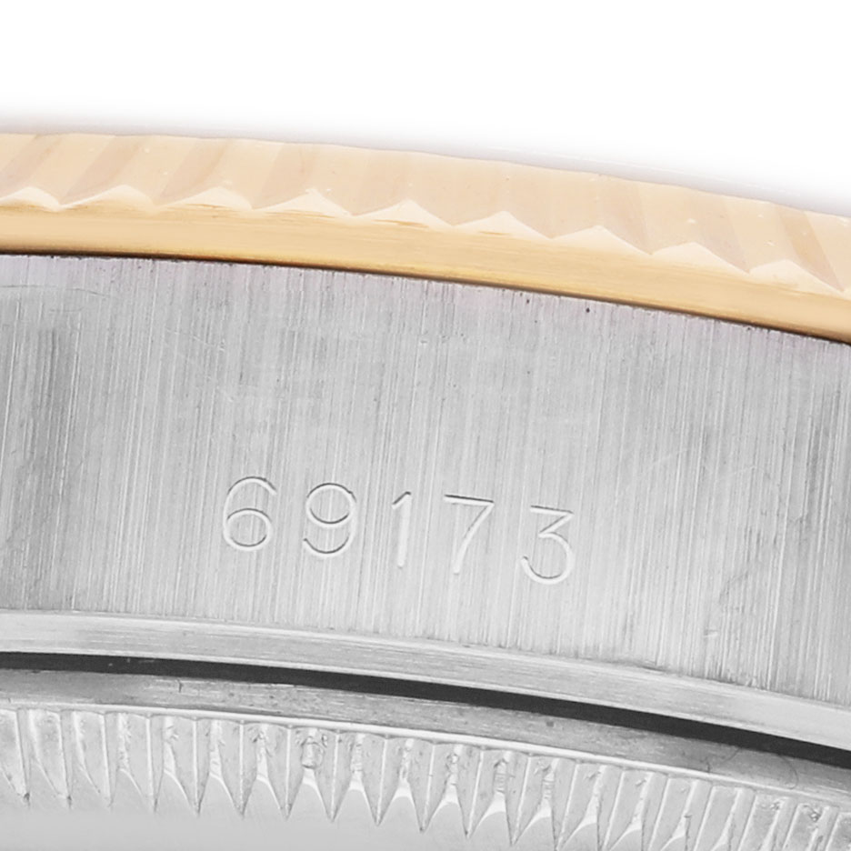 The image shows the edge and serial number engraving of a Rolex Datejust 69173 Women's Steel and Gold (two tone) Champagne Dial watch case.