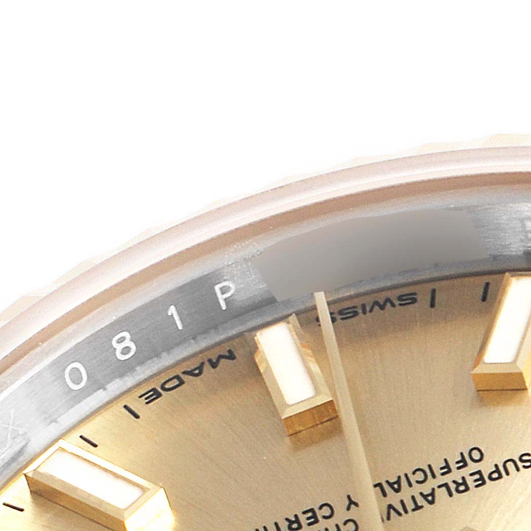Close-up of the Rolex Datejust 26216 Men's Steel and Gold (two tone) Champagne Dial 26216 Men's Steel and Gold (two tone) Champagne Dial watch showing part of the dial, markers, and inner bezel with serial engraving.
