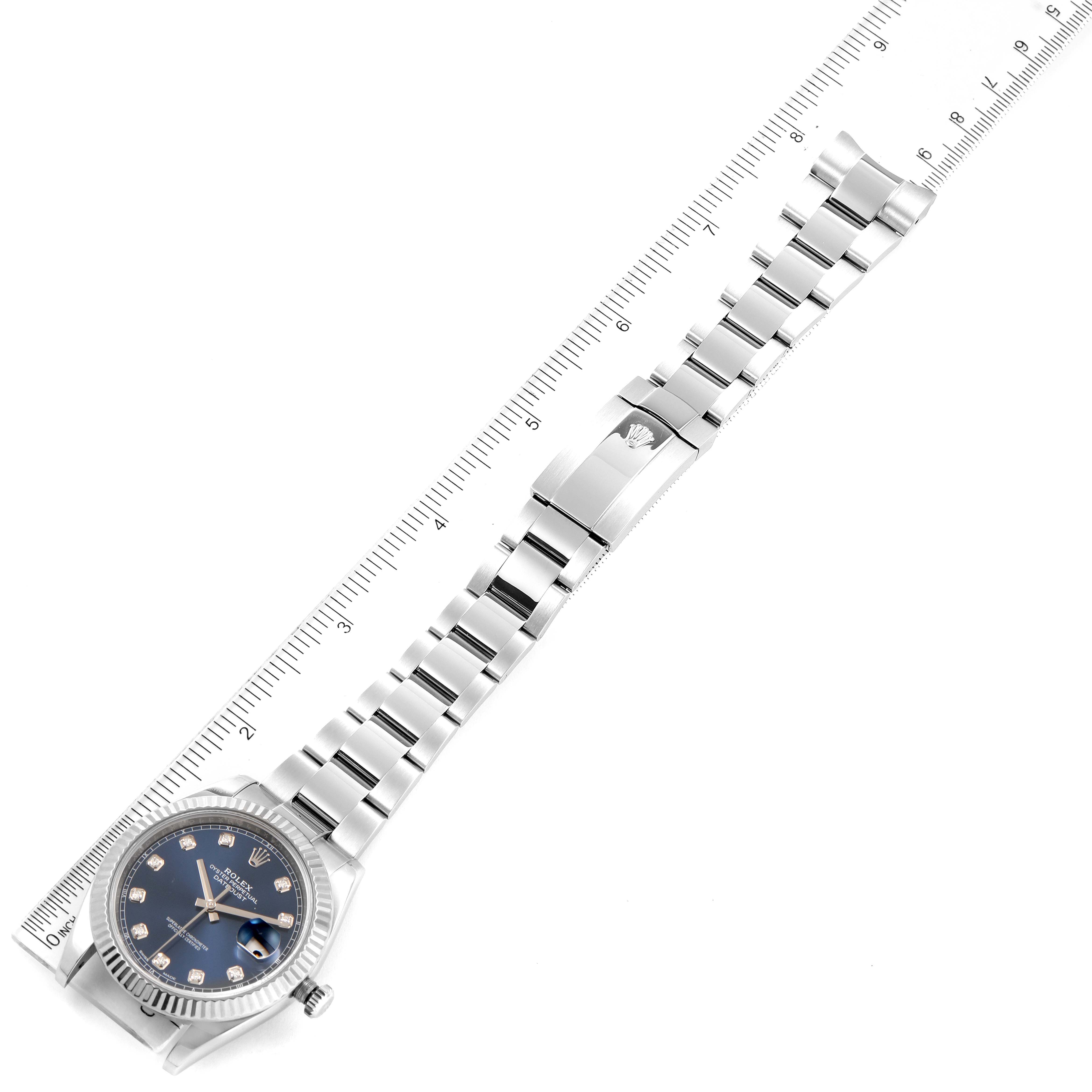 The image displays a Rolex Datejust 41 126334 Men
s Stainless Steel Blue Dial 126334 Men
s Stainless Steel Blue Dial watch laid flat with its band open and aligned with a ruler.