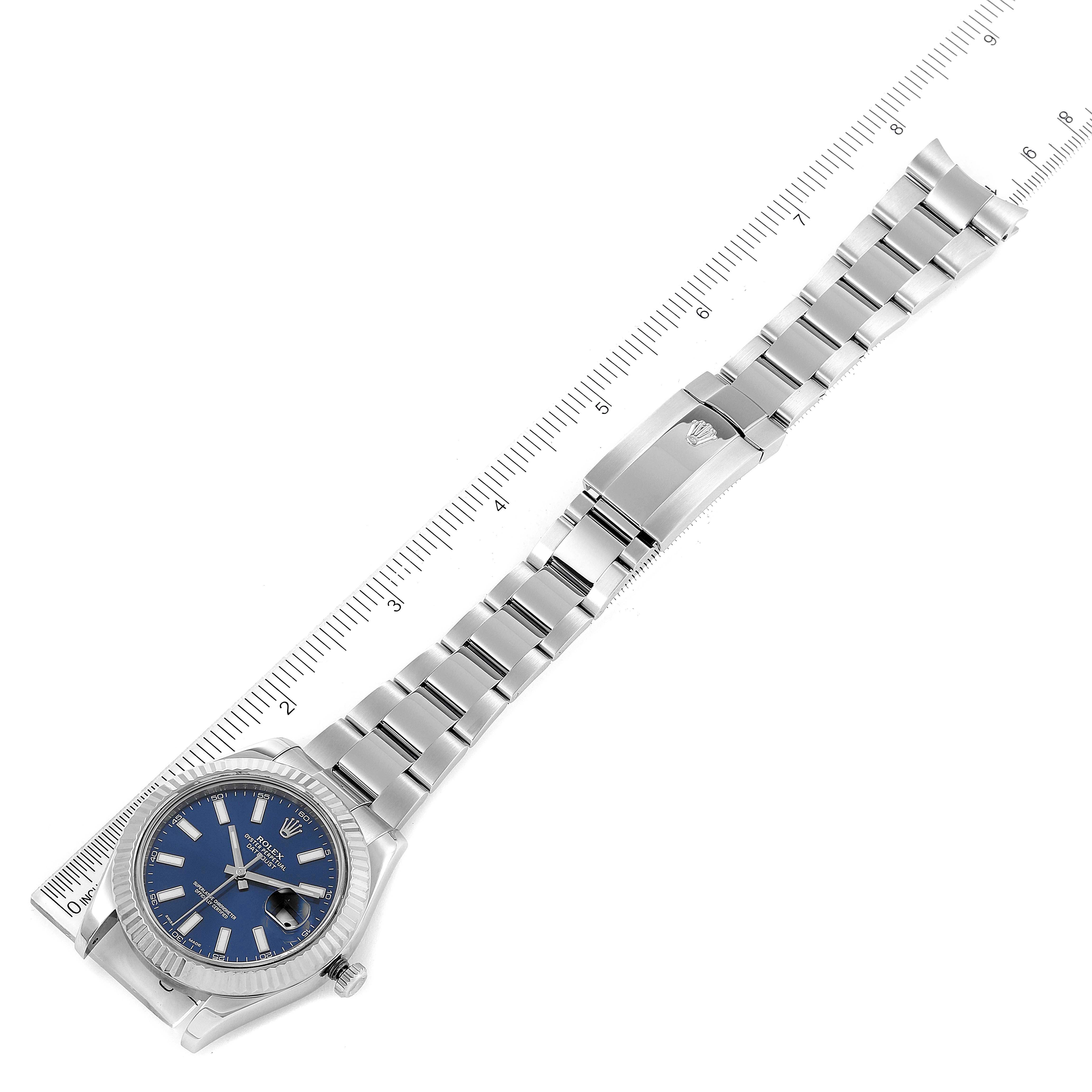 The Rolex Datejust 41 116334 Men
s Stainless Steel Blue Dial is shown from an overhead angle, highlighting its blue dial, case, and full bracelet with a measuring scale beside it.
