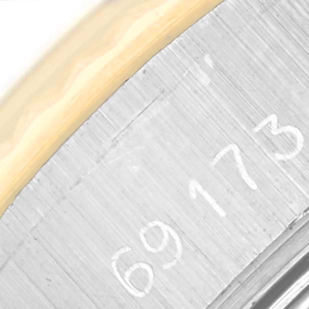 The image shows a close-up of the Rolex Datejust 69173 Women
s Stainless Steel Black Dial model
s case side, featuring its serial number and part of the bezel edge.