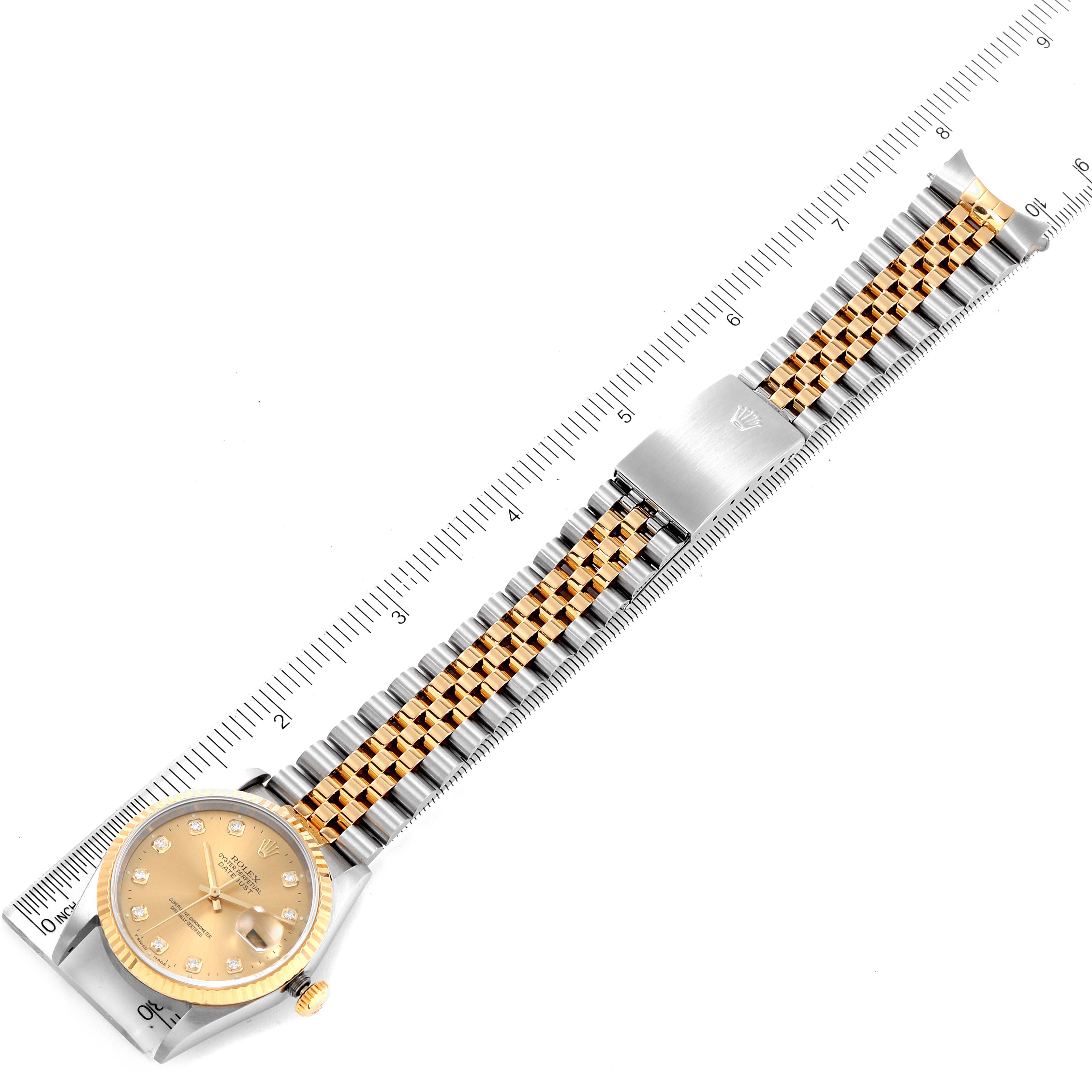 The Rolex Datejust 16233 Men's Steel and Gold (two tone) Champagne Dial 16233 Men's Steel and Gold (two tone) Champagne Dial watch is shown from an overhead view, displaying the face, bezel, and full bracelet on a ruler for scale.