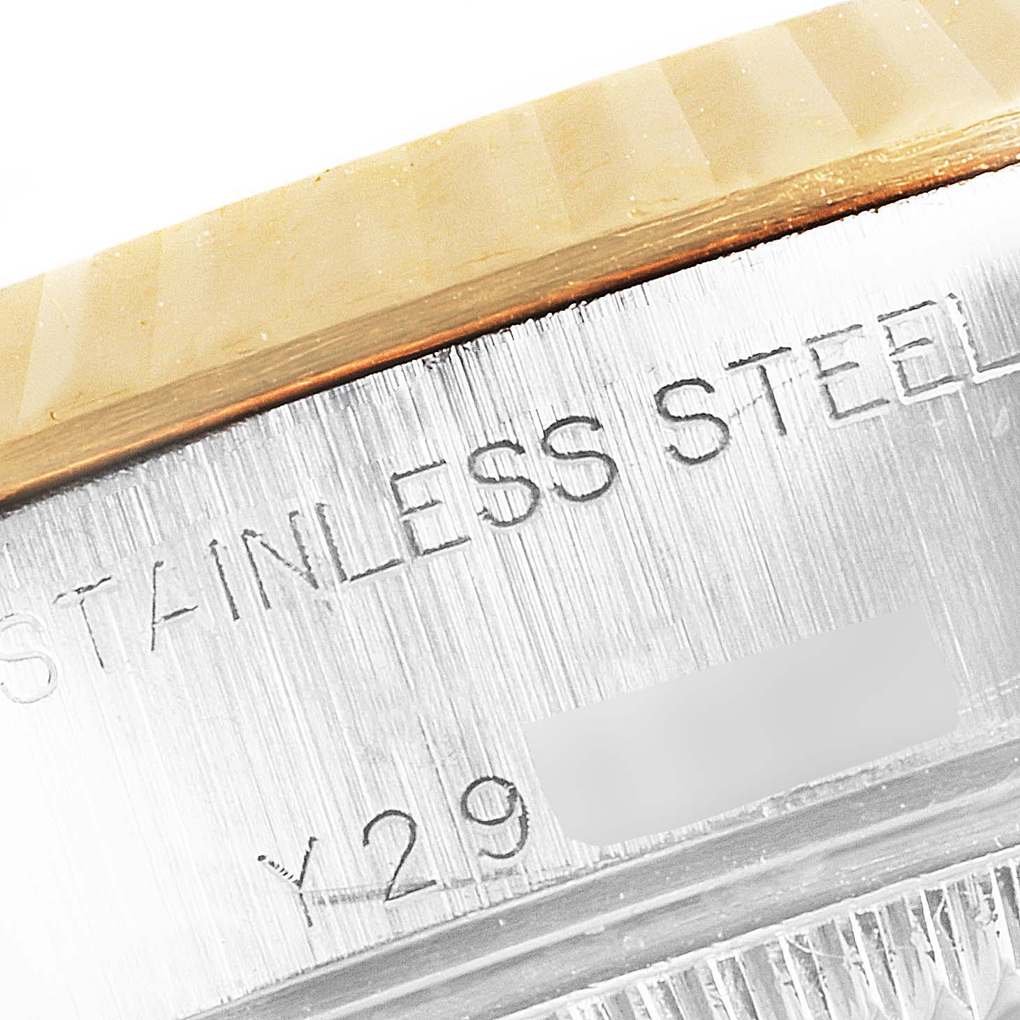 This close-up image shows part of the stainless steel case with engraved text of a Rolex Datejust 79173 Women's Steel and Gold (two tone) White Dial 79173 Women's Steel and Gold (two tone) White Dial watch.