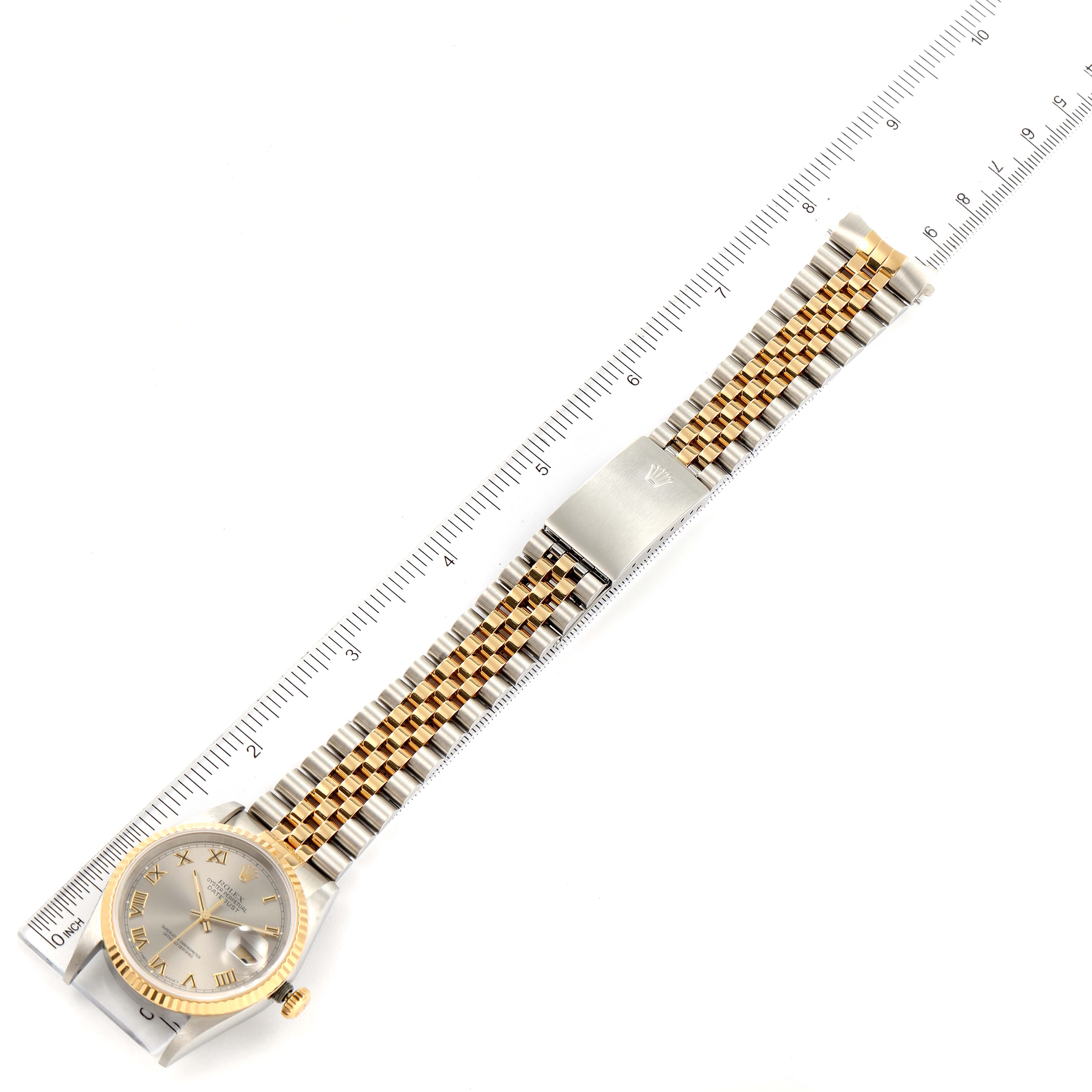 The image shows a top-down view of a Rolex Datejust 16233 Men
s Steel and Gold (two tone) Grey Dial 16233 Men
s Steel and Gold (two tone) Grey Dial watch with a silver and gold Jubilee bracelet next to a ruler for scale.