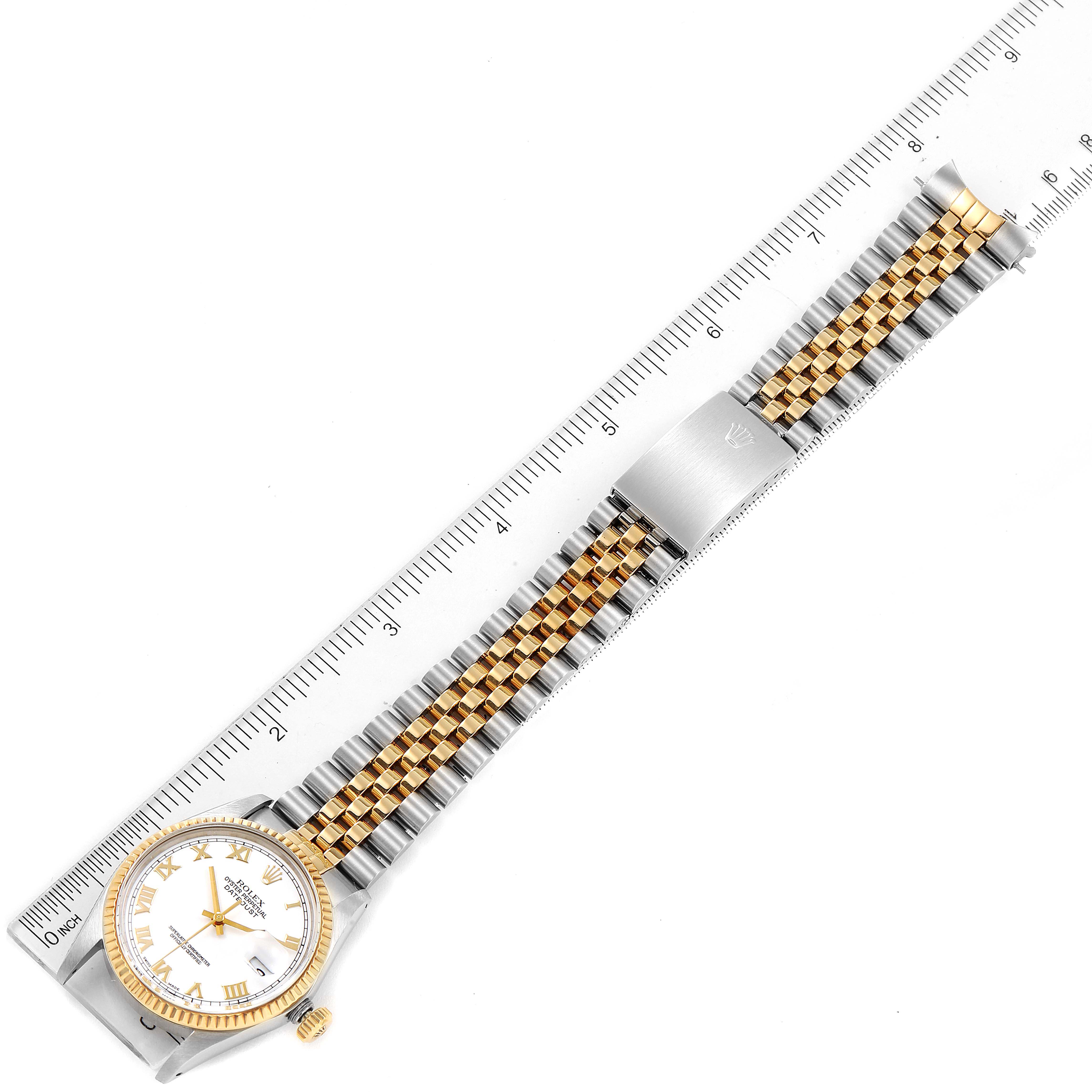 The image shows a full view of a Rolex Datejust 16013 Men's Steel and Gold (two tone) White Dial 16013 Men's Steel and Gold (two tone) White Dial watch with a two-tone bracelet placed next to a ruler.