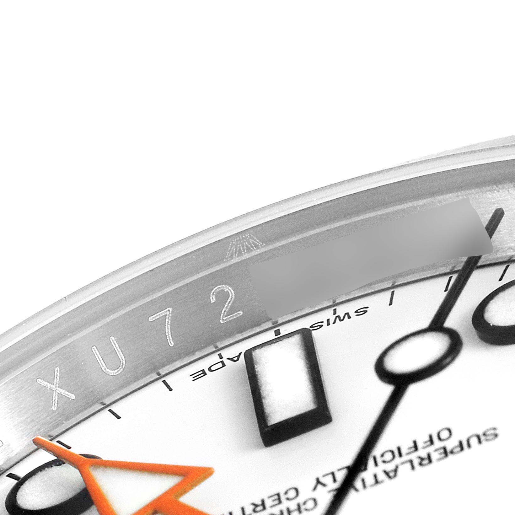 This is a close-up of the Rolex Explorer 216570 Men
s Stainless Steel White Dial 216570 Men
s Stainless Steel White Dial watch, showing its serial number engraving, part of the dial, and the orange hand.